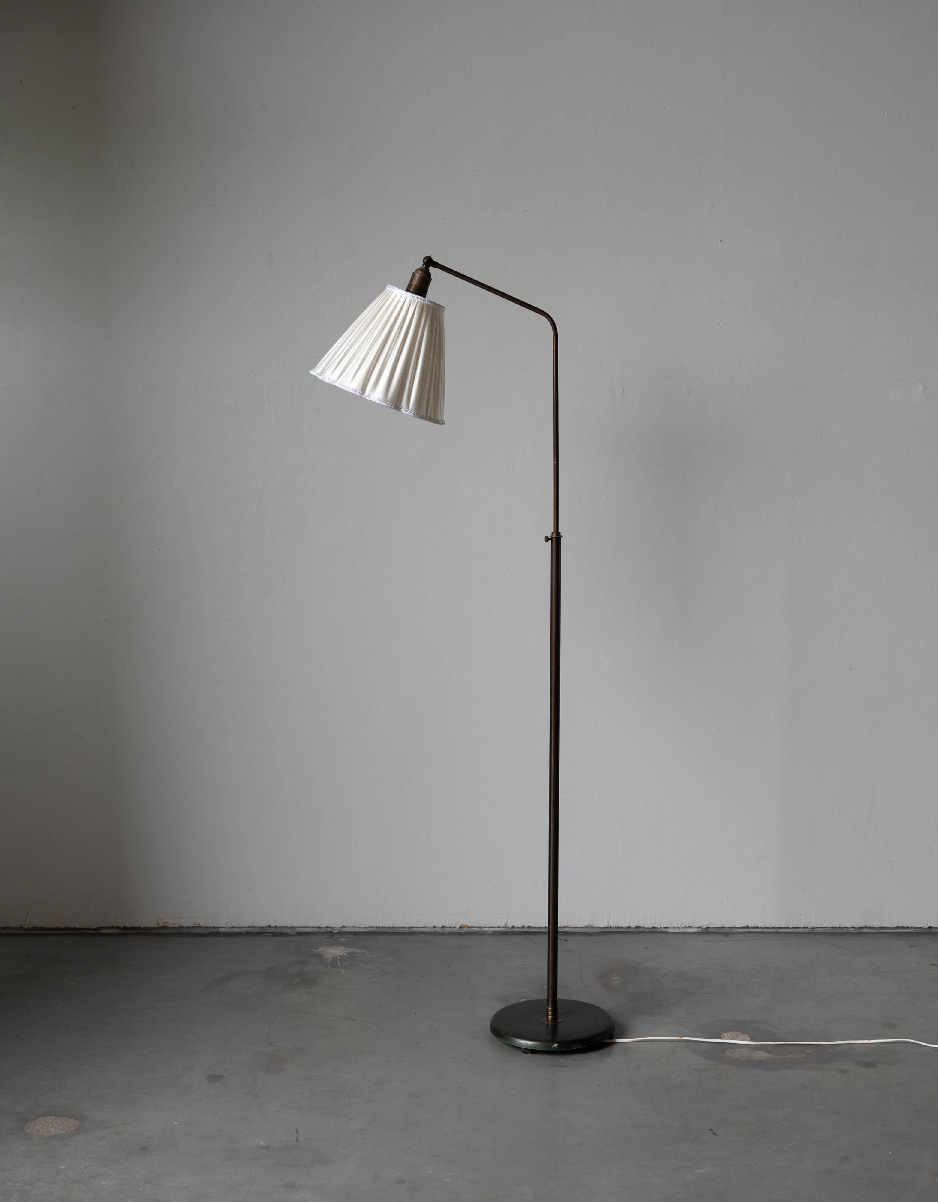 A brass and fabric floor lamp designed and produced in Denmark, 1940s. 

Sold with lampshade. 
Dimensions stated refer to the floor lamp with shade. 

Variable dimensions, measured as illustrated in the first image.