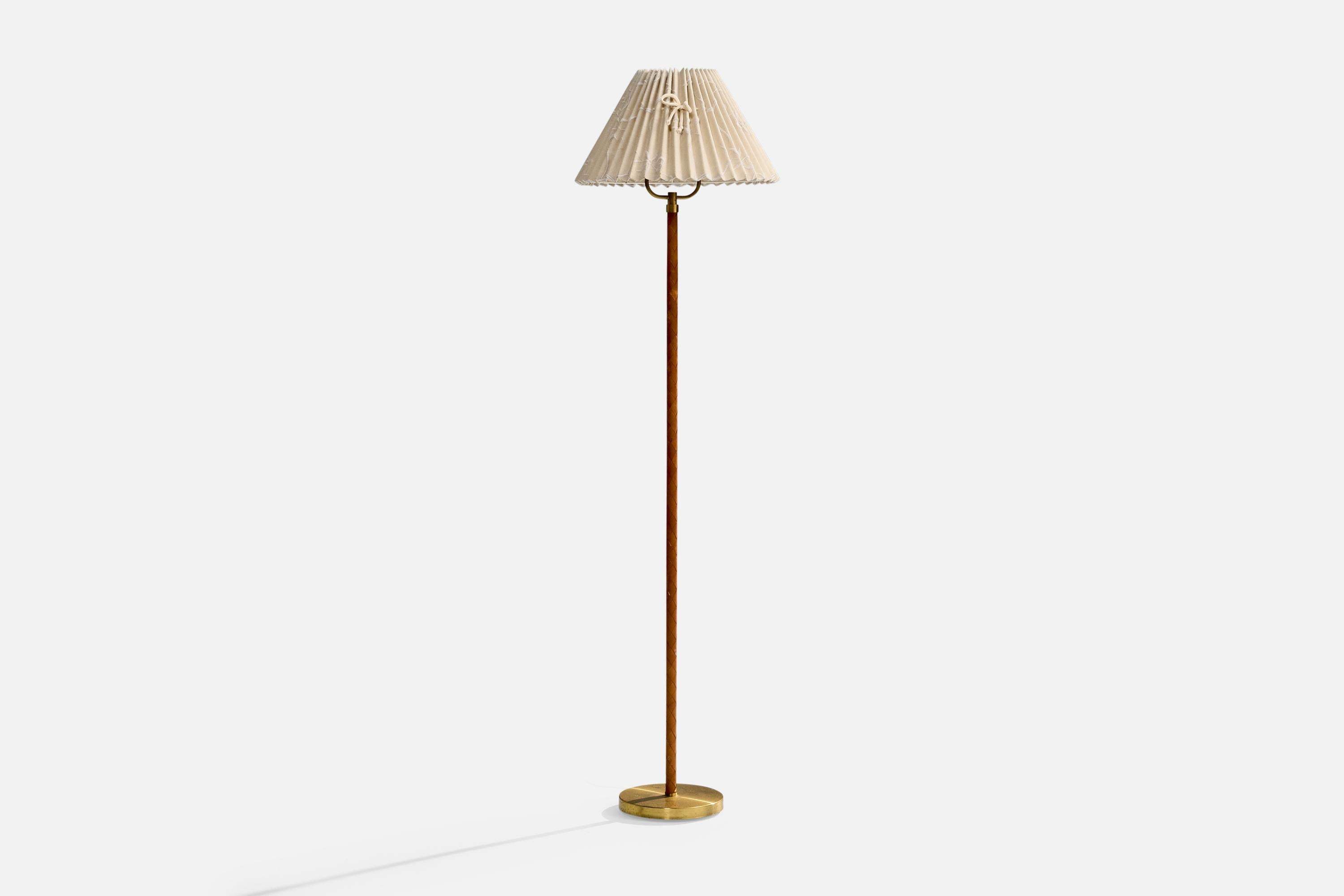 A brass, brown leather and beige fabric floor lamp designed and produced in Denmark, c. 1940s.

The brass base presents with heavy oxidation. Vintage lampshade in fair condition.

Light wear to leather, consistent with age and use.

Dimensions of