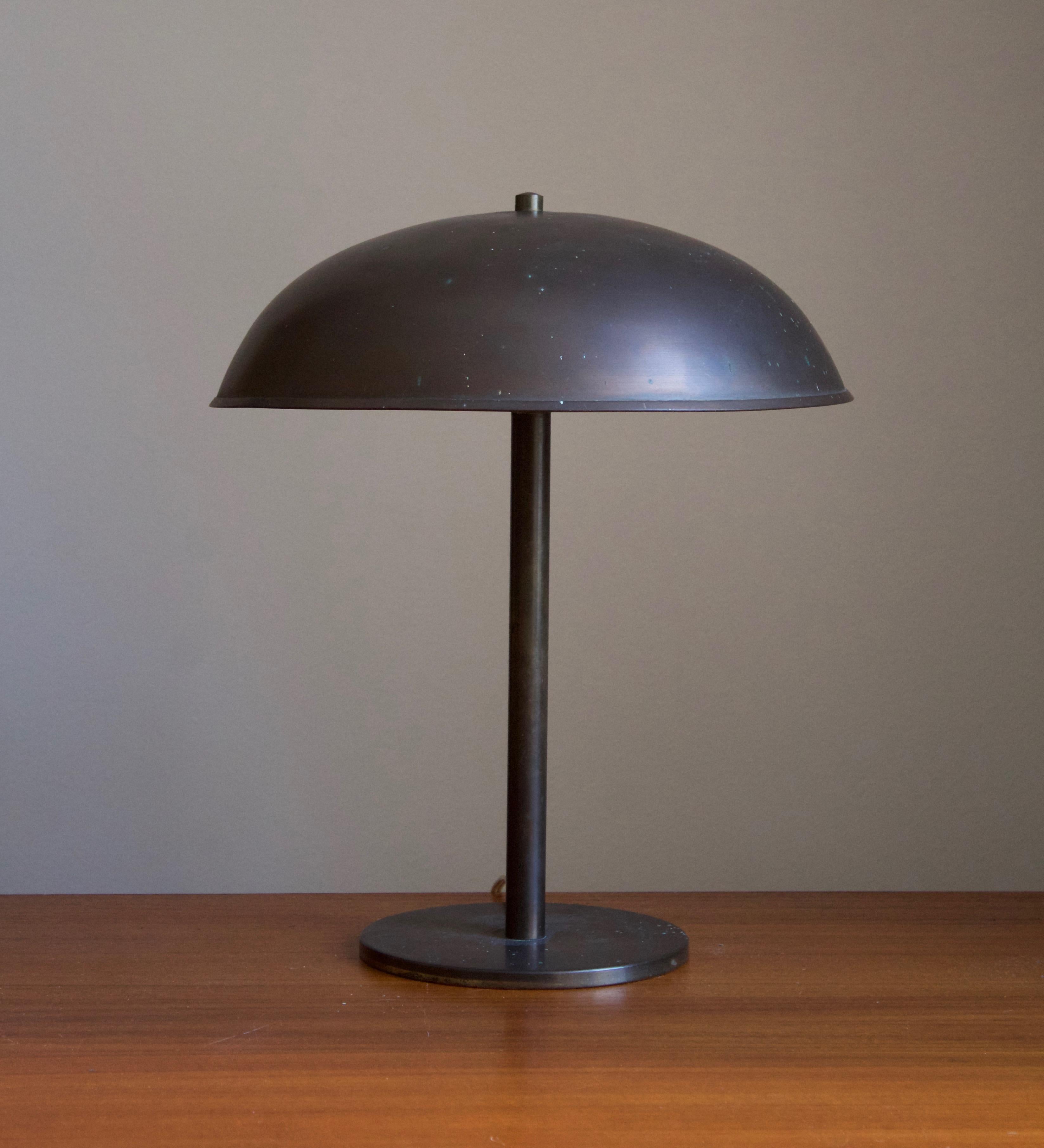 A desk light / table lamp. Designed and produced in Denmark, 1930s. Features brass that has retained a dramatic patina over the decades.