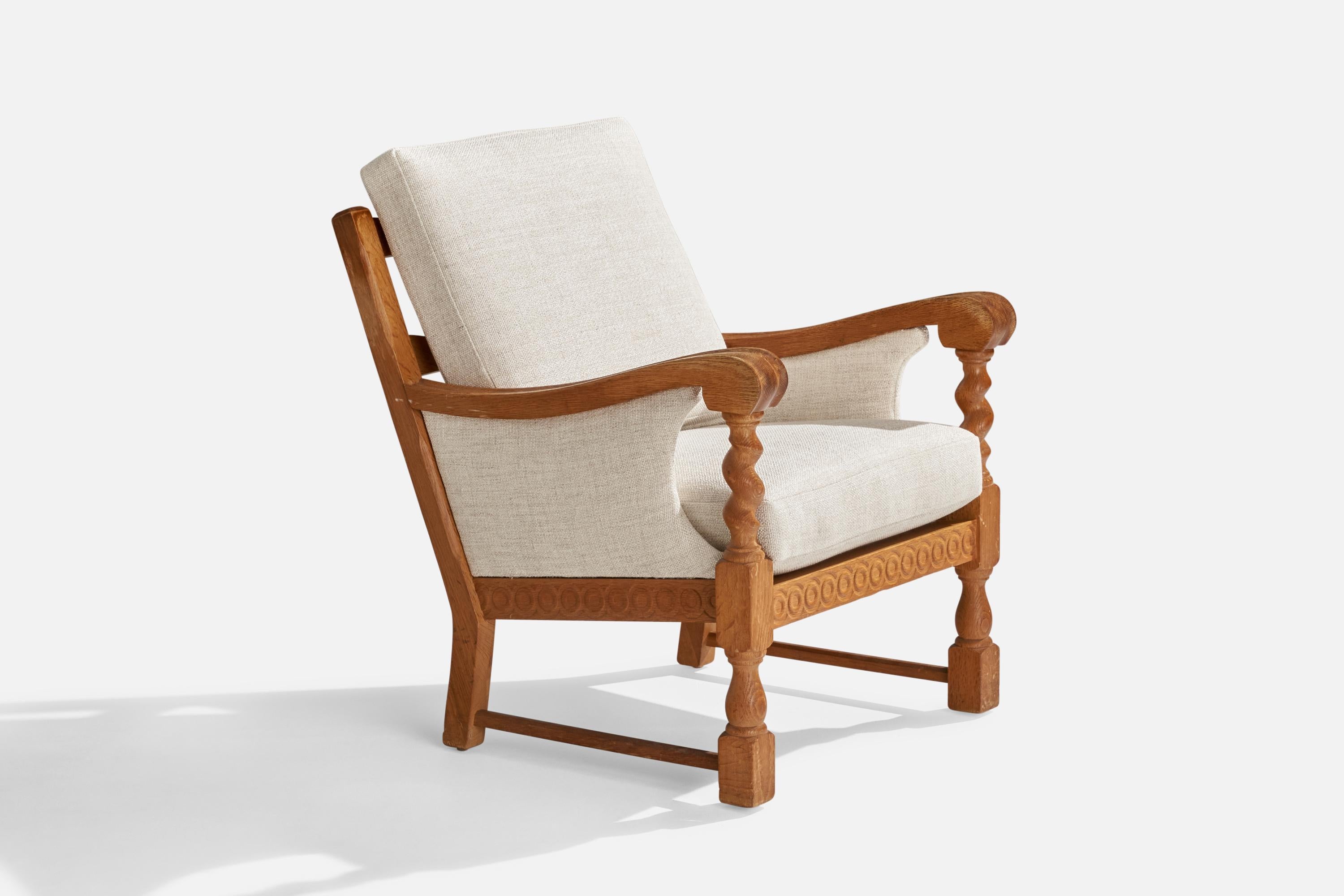 An oak and white fabric lounge chair designed and produced in Denmark, 1960s.

Seat height: 17.25”