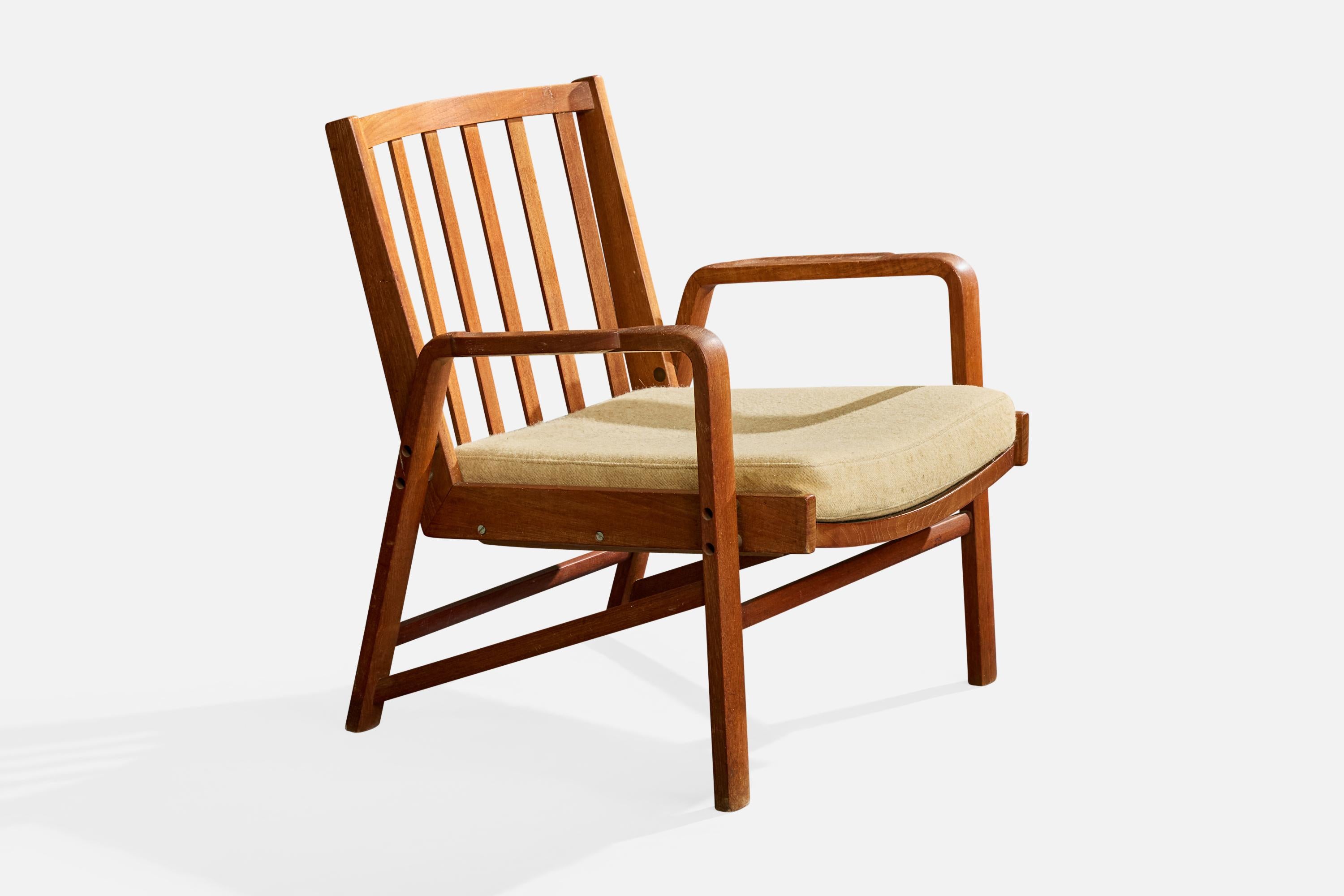 An oak and fabric lounge chair designed and produced in Denmark, c. 1960s.

Fabric on removable cushion has mild stains on one side, moderate stains on other.

Mild to moderate imperfections throughout wood frame.

Overall Dimensions (inches):