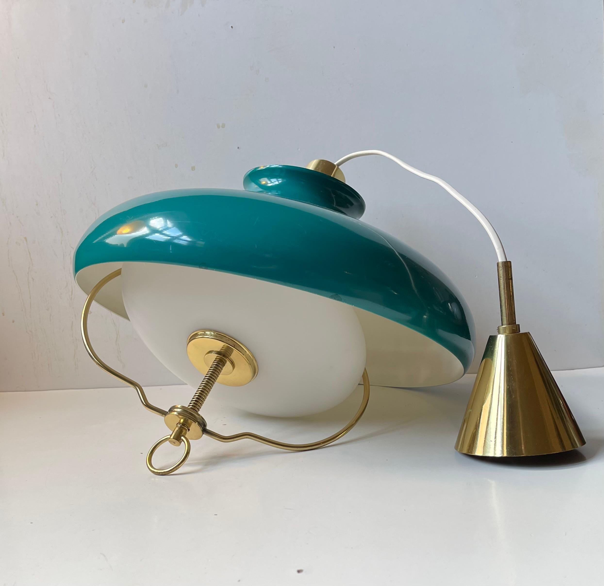 A very rare nautical/martime pendant ceiling lamp composed of a high-quality brass base, adjustable opaline inner-shade with brass accents and a gorgeous teal green aluminum outer shade. It was manufactured by Lyft in Denmark circa 1950-60s and may