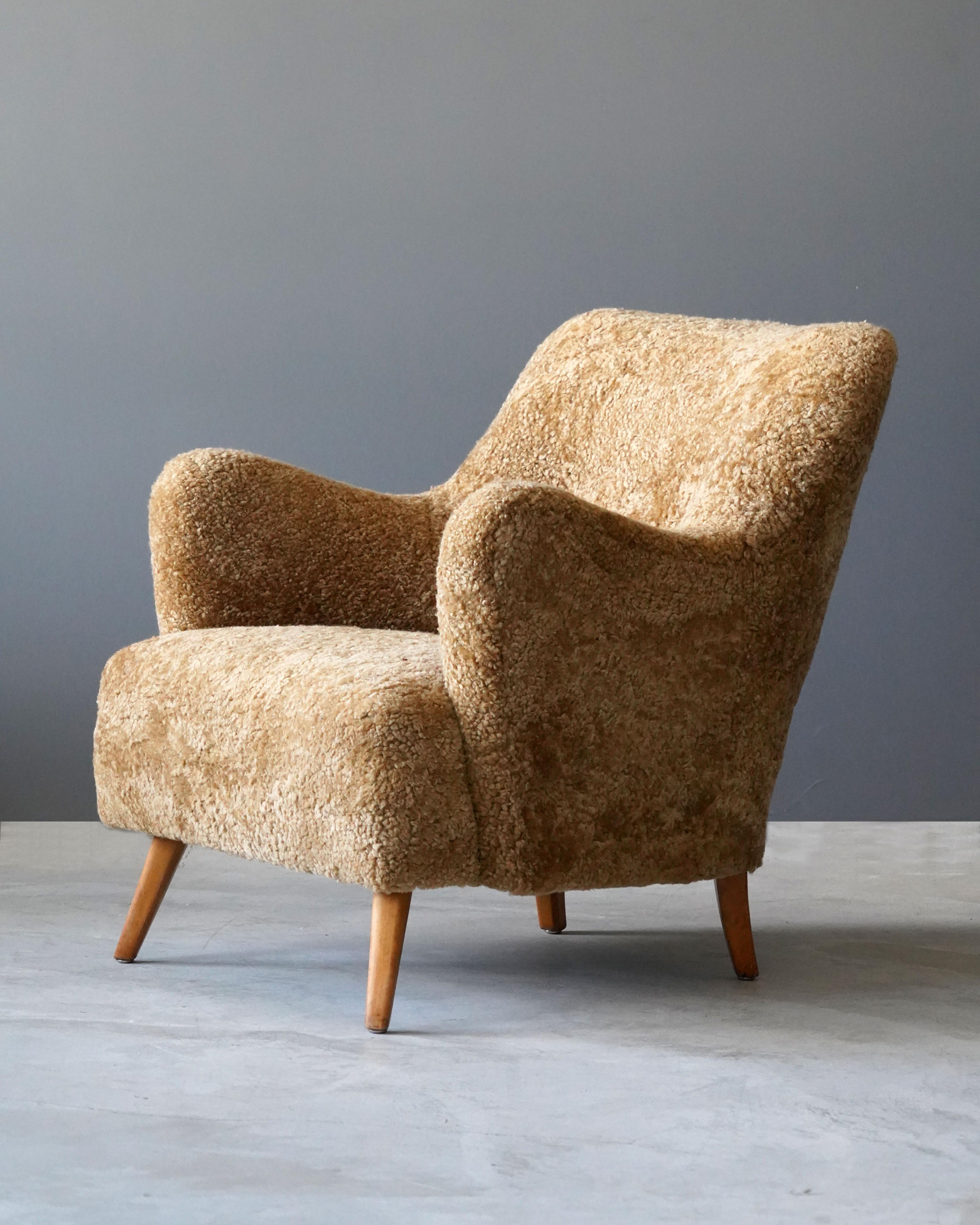 An organic lounge chair or armchair, designed by an unknown Danish modernist designer, late 1940s or early 1950s.

The sofa organic form is further enhanced by the sheepskin upholstery.

Other designers working in similar organic style include