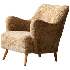 Designer danois:: chaise longue organique:: peau de mouton beige:: hêtre:: Danemark:: années 1940
