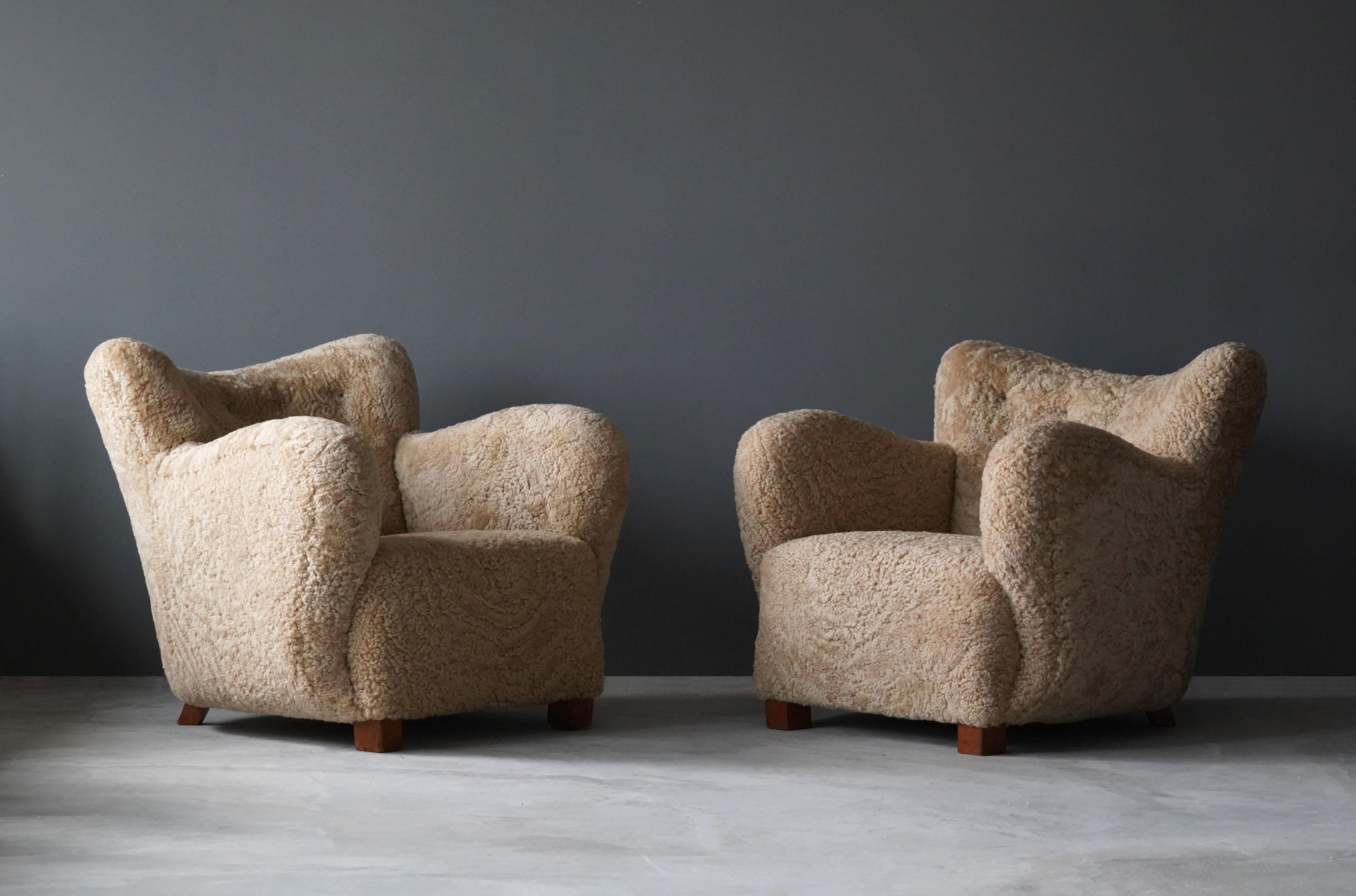 A pair of organic modernist lounge chairs. Designed and produced in Denmark, 1940s. Reupholstered in brand new authentic shearling upholstery. 

Similar in style to works by designers such as Flemming Lassen, Gio Ponti, Vladimir Kagan, Philip