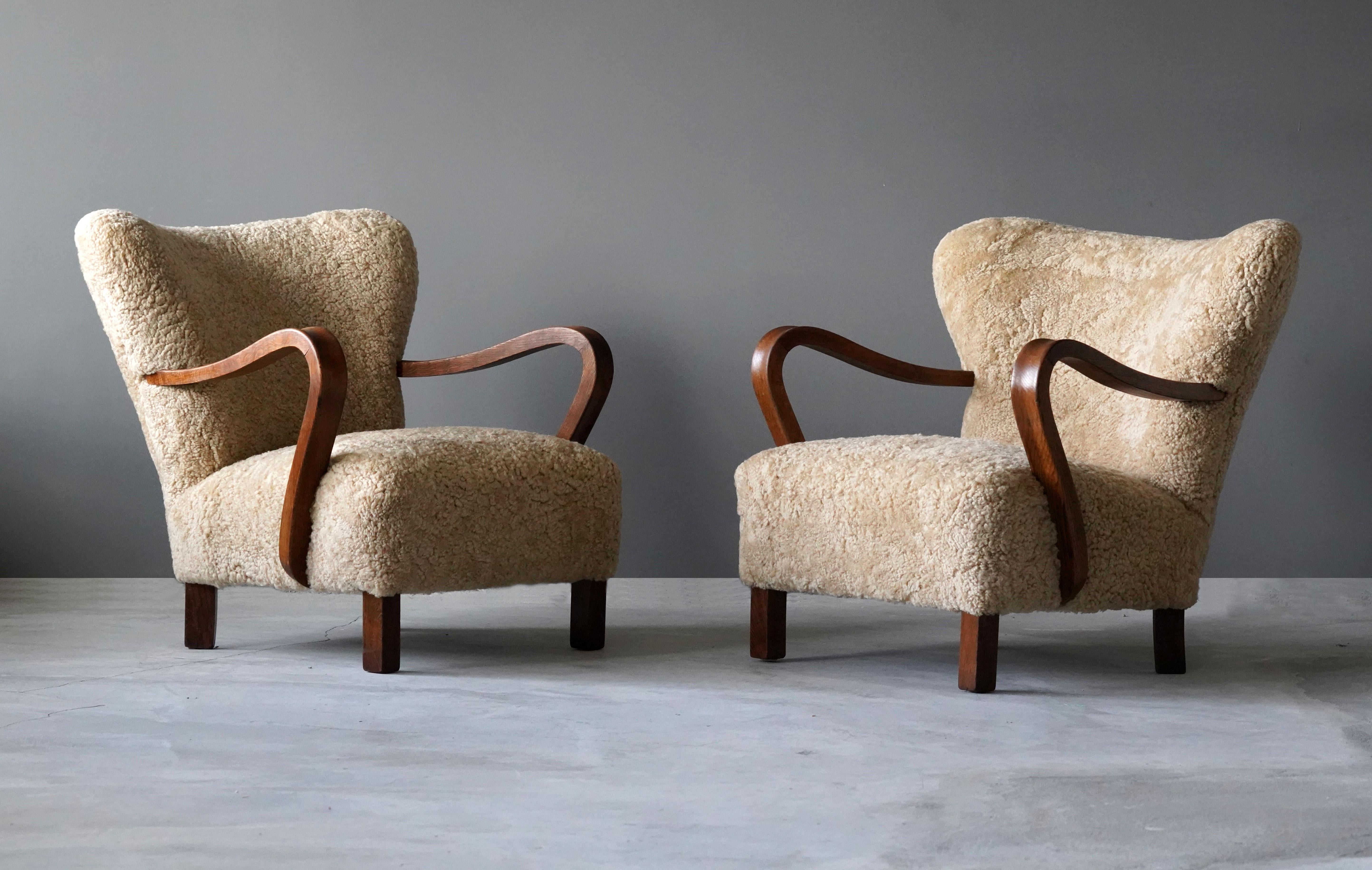 A pair of organic modernist lounge chairs. Designed and produced in Denmark, 1940s. Reupholstered in brand new authentic shearling upholstery. 

Similar in style to works by designers such as Flemming Lassen, Gio Ponti, Vladimir Kagan, Philip