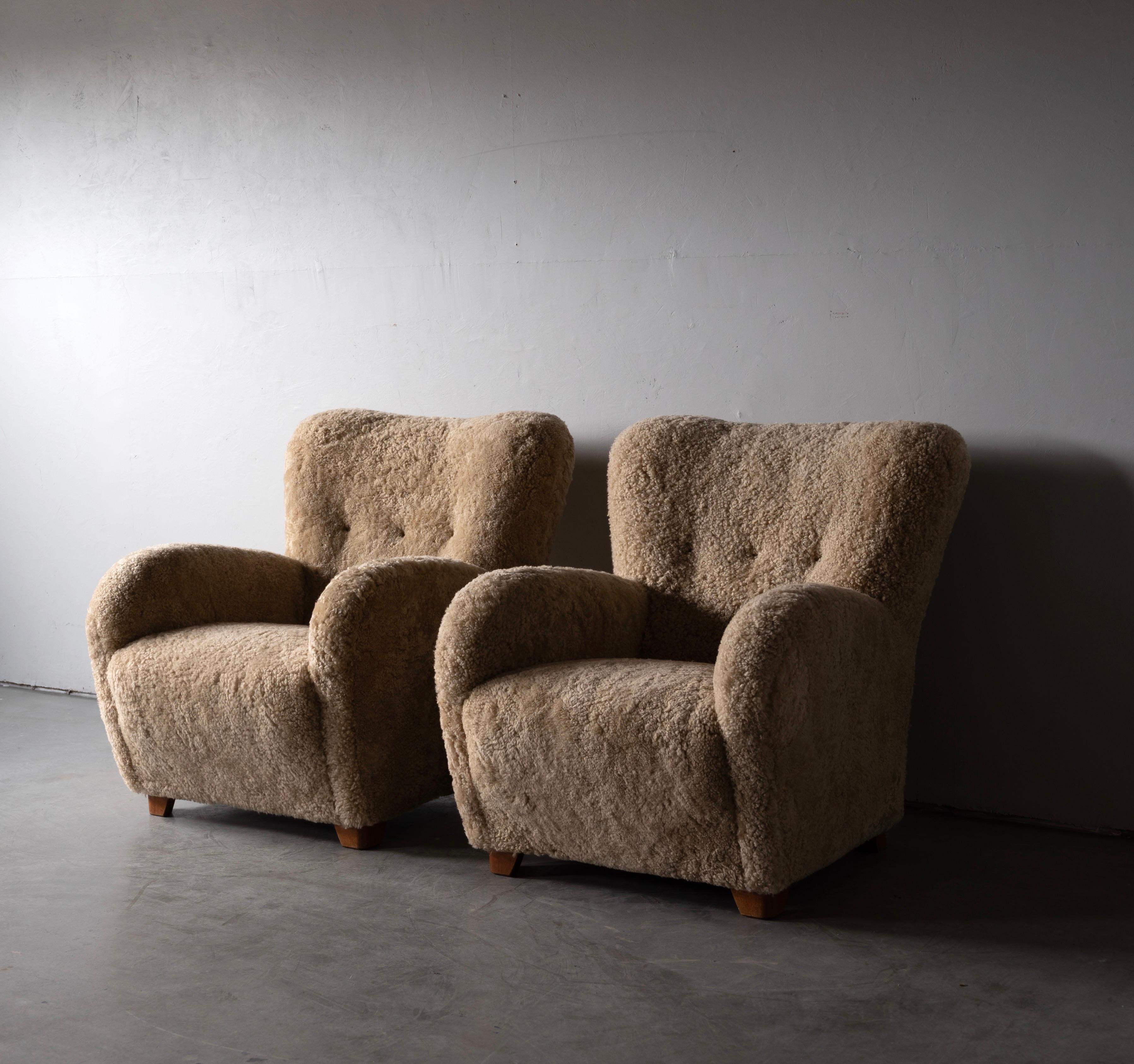 A pair of organic modernist lounge chairs. Designed and produced in Denmark, 1940s. Reupholstered in brand new authentic shearling upholstery. Stained wooden legs. 

Similar in style to works by designers such as Flemming Lassen, Gio Ponti,