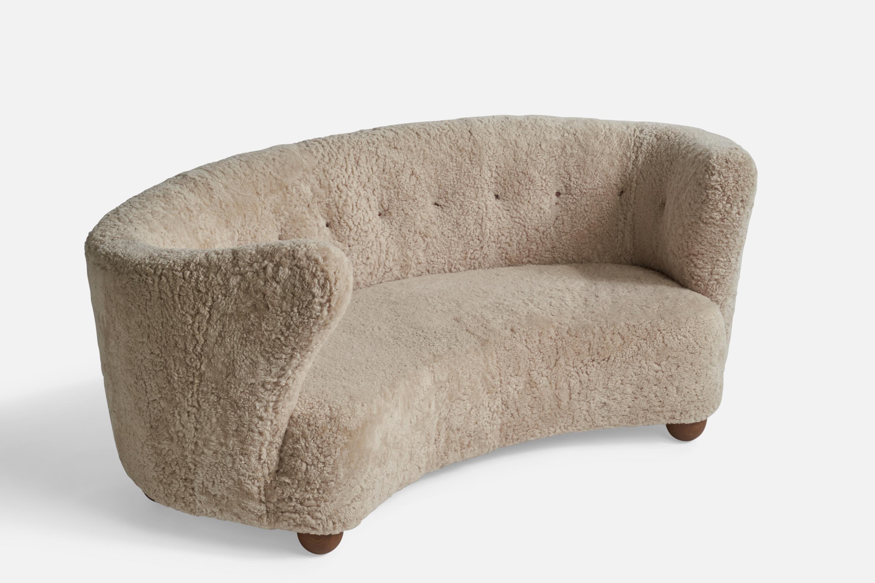 A organic curved beige shearling and wood sofa designed and produced in Denmark, 1940s.

Seat height: 15”
