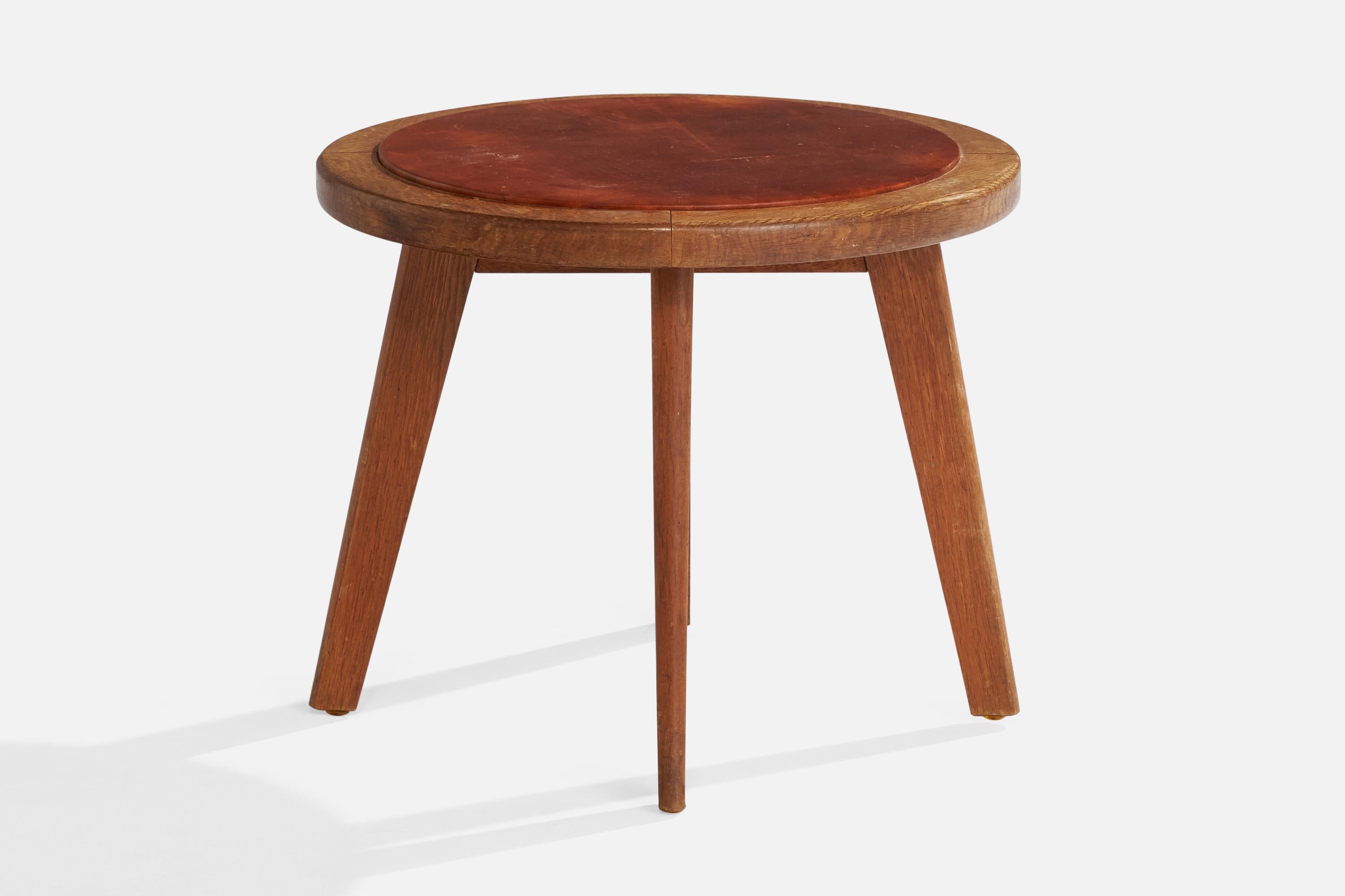 Mesa auxiliar de roble y cuero marrón diseñada y fabricada en Dinamarca, c. década de 1940.

Dimensiones: 17,7