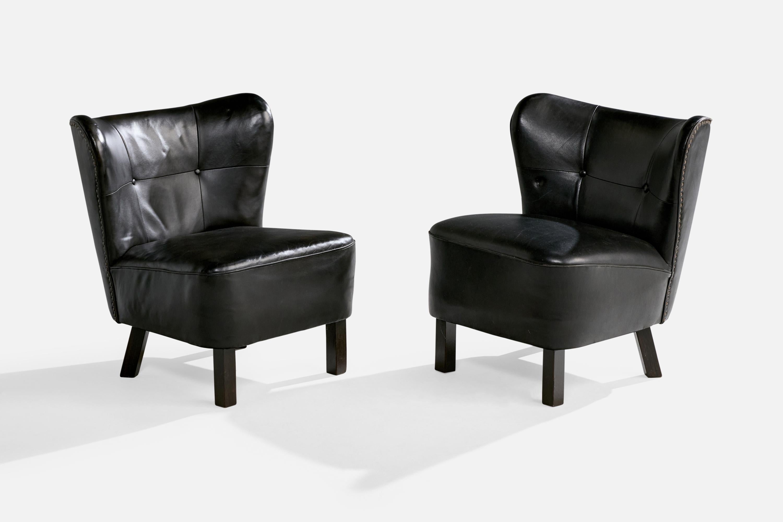 Paire de chaises à pantoufles en cuir noir et en bois peint en noir, conçues et produites au Danemark, vers les années 1940.

Dimensions globales (pouces) : 27.375