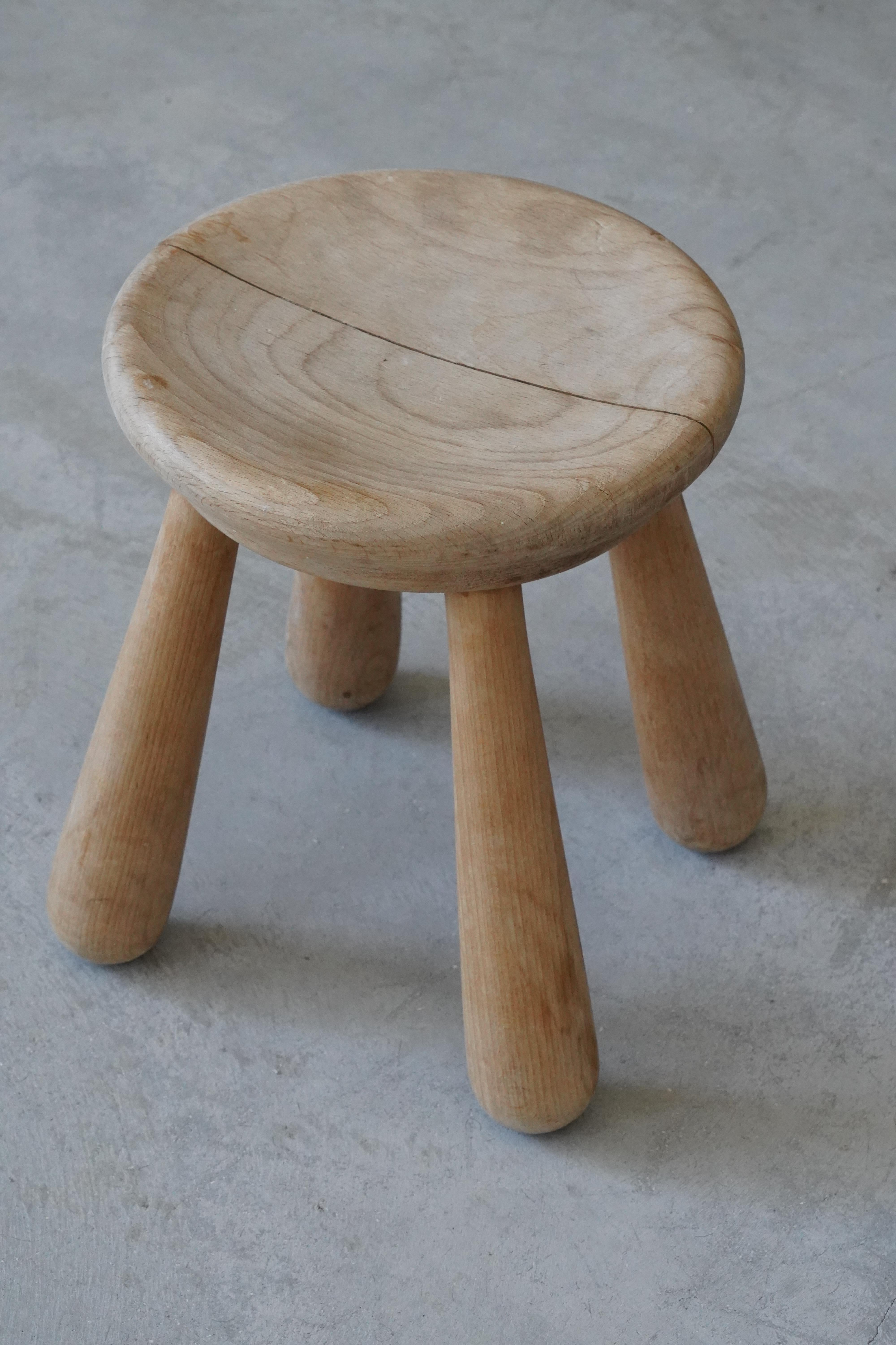 A small finely carved oak stool. Produced in Denmark, c. 1940s. 

  