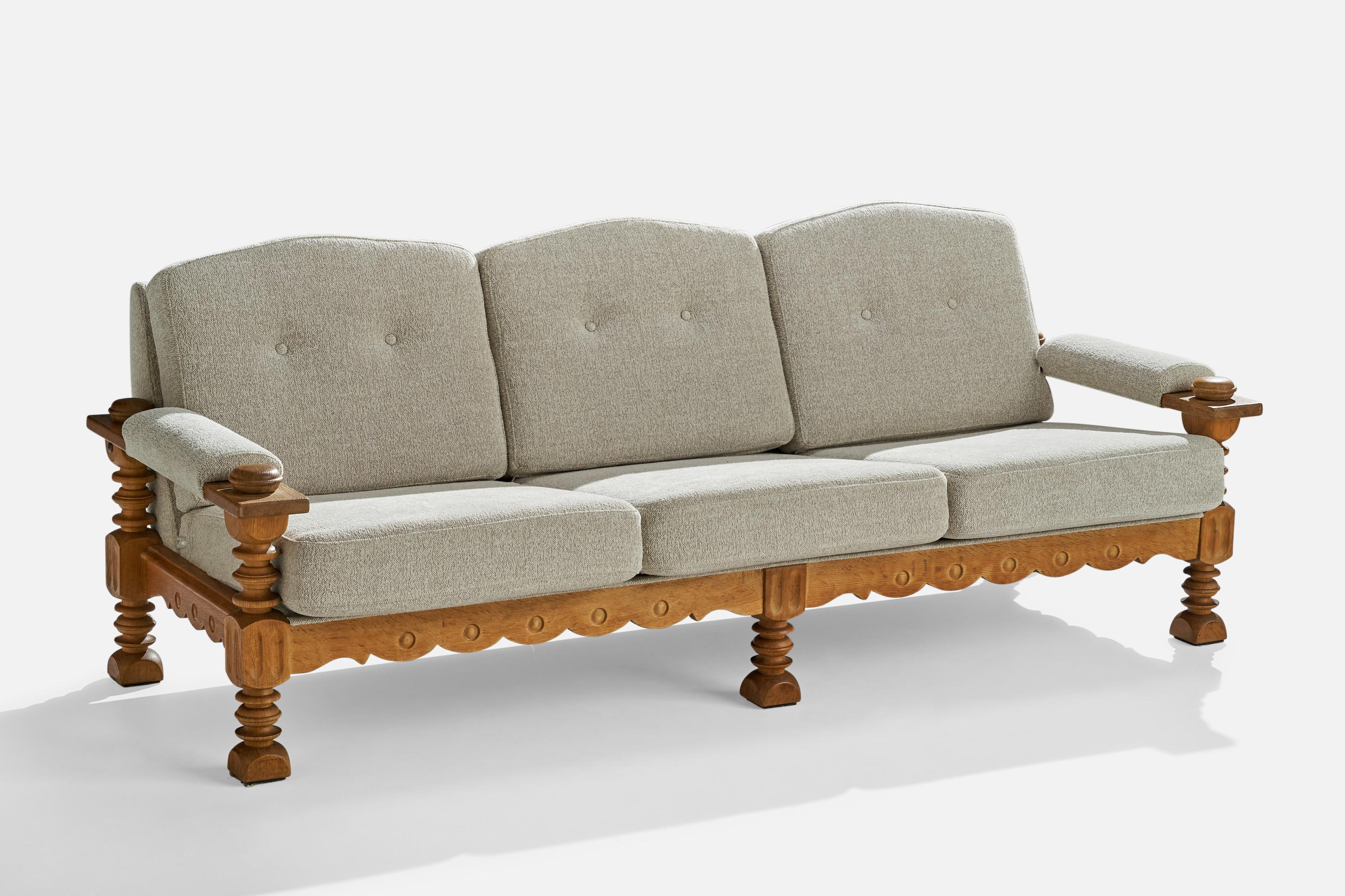 A carved oak and light grey fabric sofa designed and produced in Denmark, c. 1960s.

Seat height 16.5”