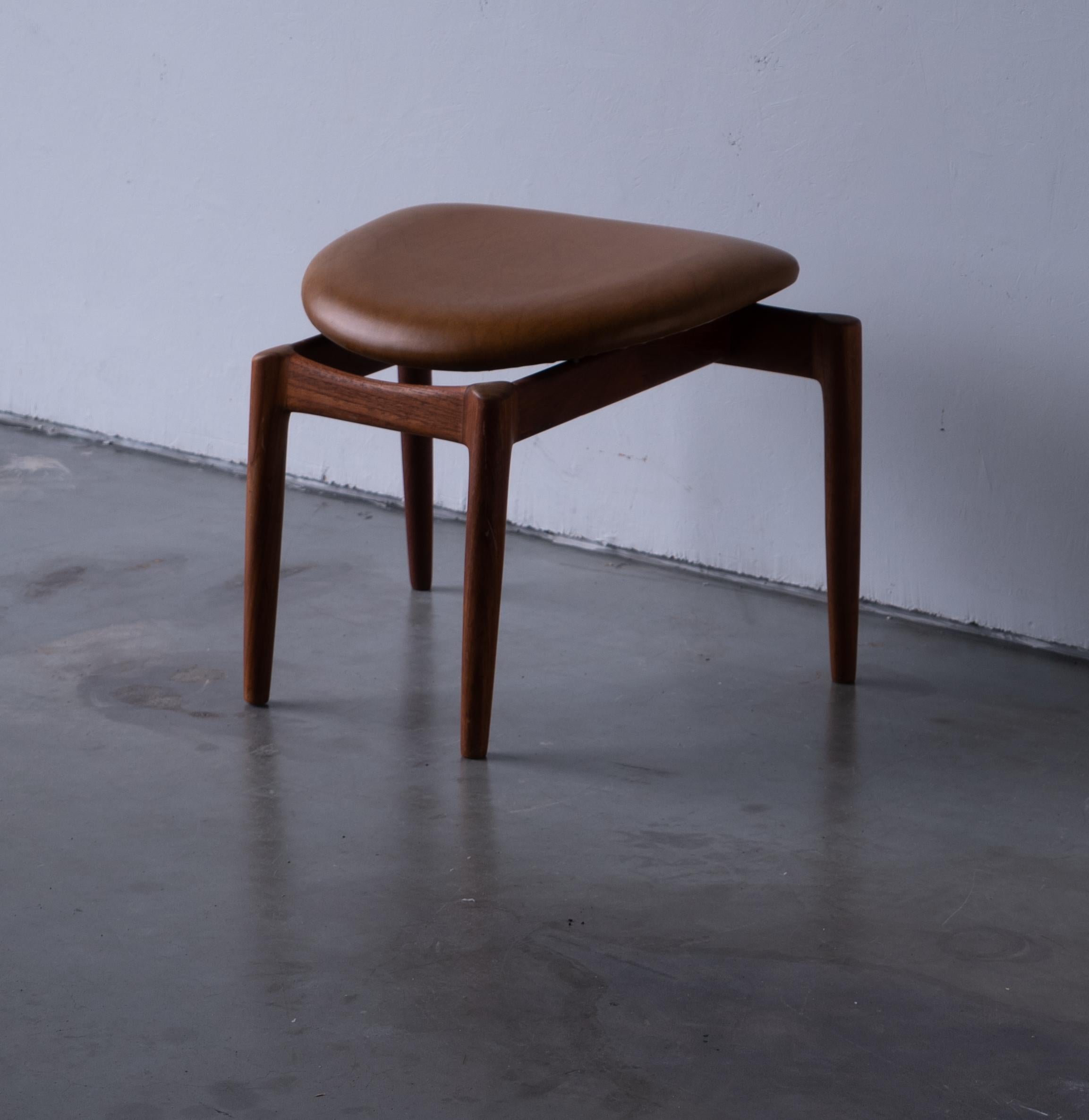 A stool, designed and produced in Denmark, c. 1950s. In teak, brown leather.