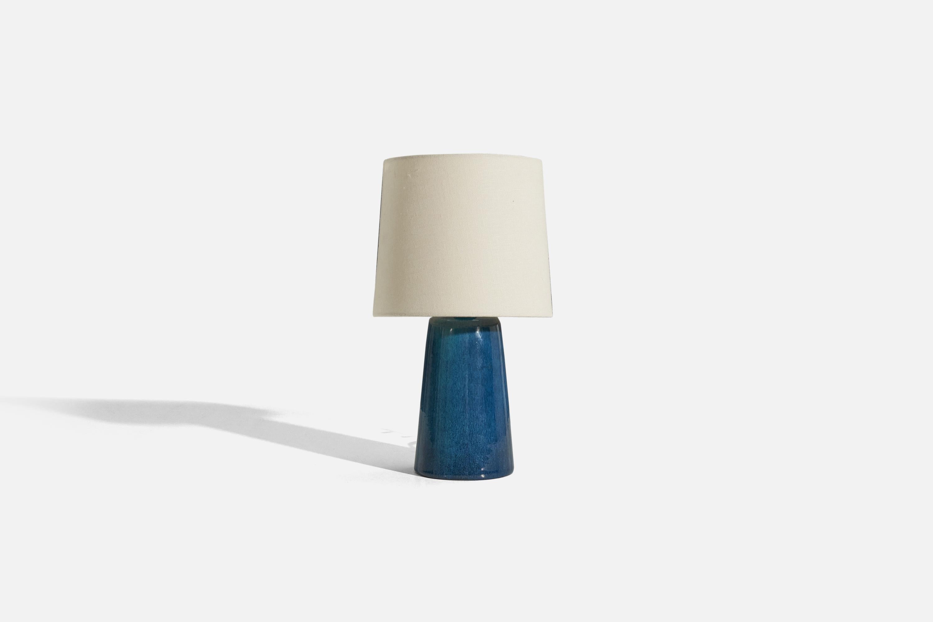 A blue-glazed stoneware and teak table lamp designed and produced in Denmark, 1960s.

Sold without lampshade. 
Dimensions of Lamp (inches) : 10.125 x 4.5 x 4.5 (H x W x D)
Dimensions of Shade (inches) : 7 x 8 x 7 (T x B x S)
Dimension of Lamp with