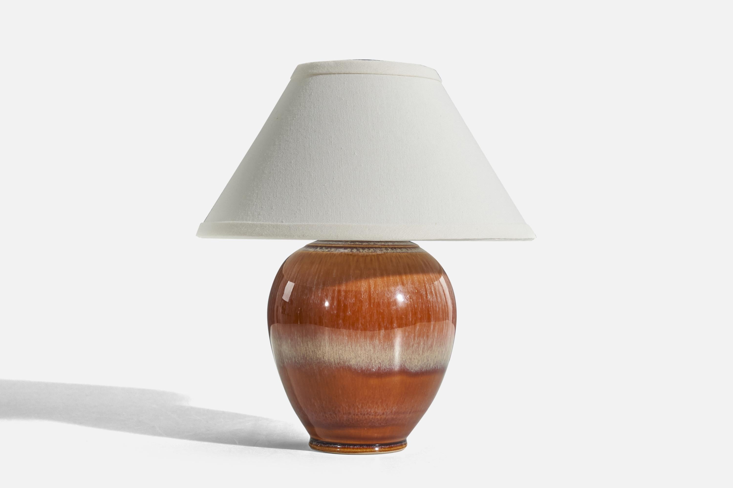 An orange glazed stoneware table lamp designed and produced by a Danish designer, Denmark, c. 1960s.

Sold without lampshade. 
Dimensions of lamp (inches) : 9 x 5.87 x 5.87 (H x W x D)
Dimensions of shade (inches) : 4.25 x 10.25 x 6 (T x B x
