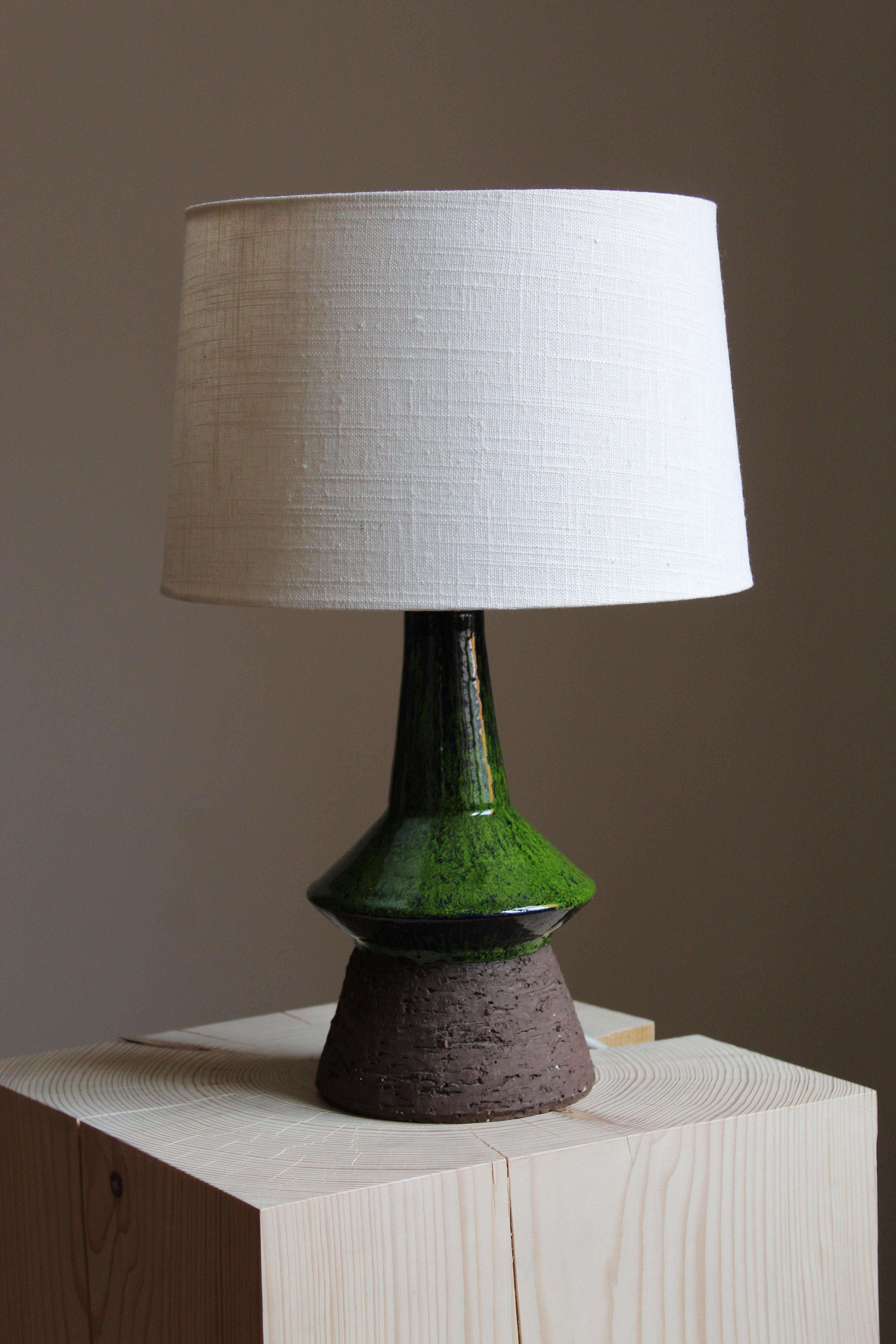 A modernist table lamp. Designed and produced in Denmark, 1950s. Unsigned. 

Sold without lampshade.

Glaze features green-grey colors.

Other designers of the period include Axel Salto, Arne Bang, Carl-Harry Stålhane, Gunnar Nylund and Wilhelm Kåge.