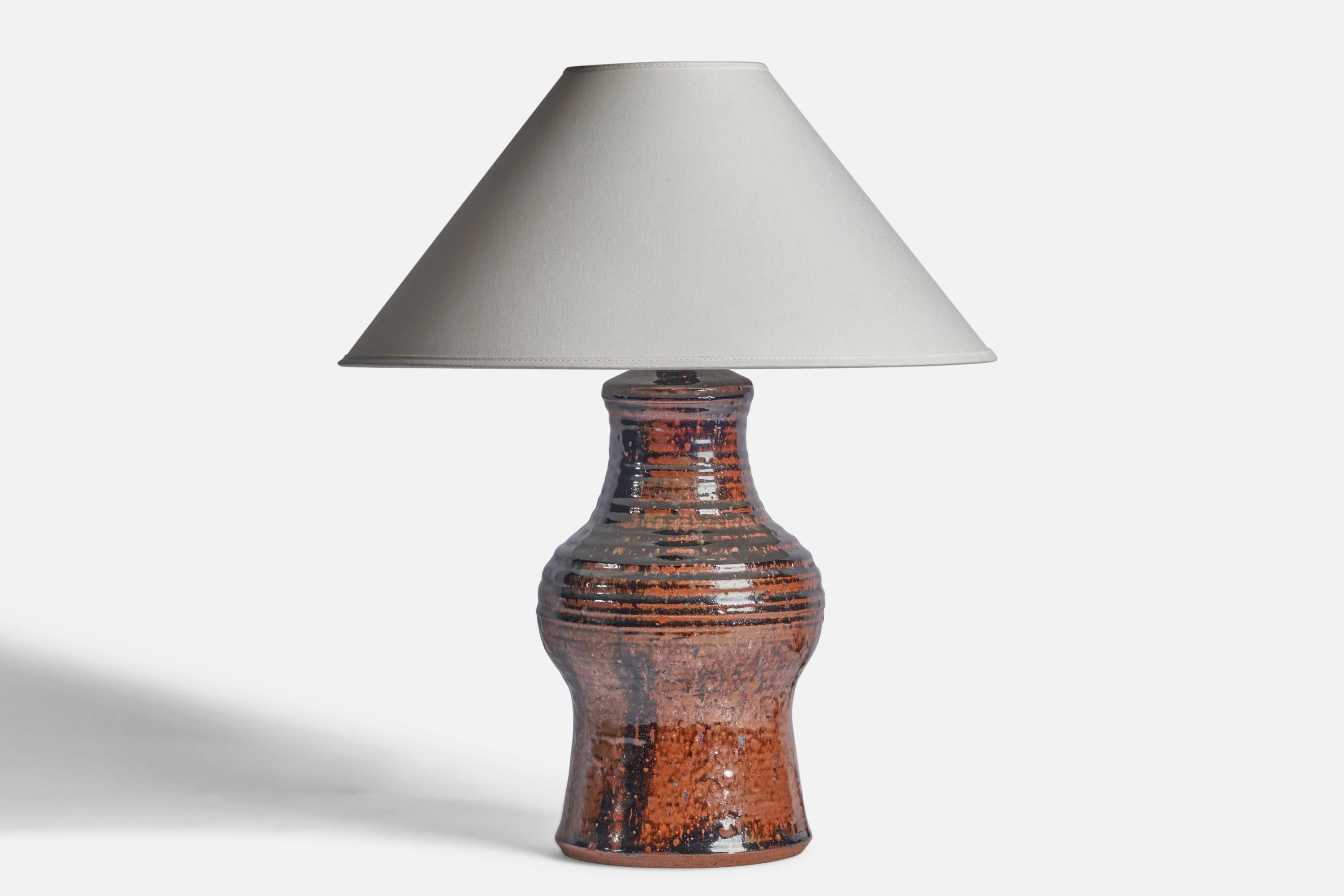A brown and black-glazed stoneware table lamp designed and produced in Denmark, c. 1950s.

Dimensions of Lamp (inches): 14.5 H x 6.5” Diameter
Dimensions of Shade (inches): 4.5” Top Diameter x 16” Bottom Diameter x 7.25” H
Dimensions of Lamp with
