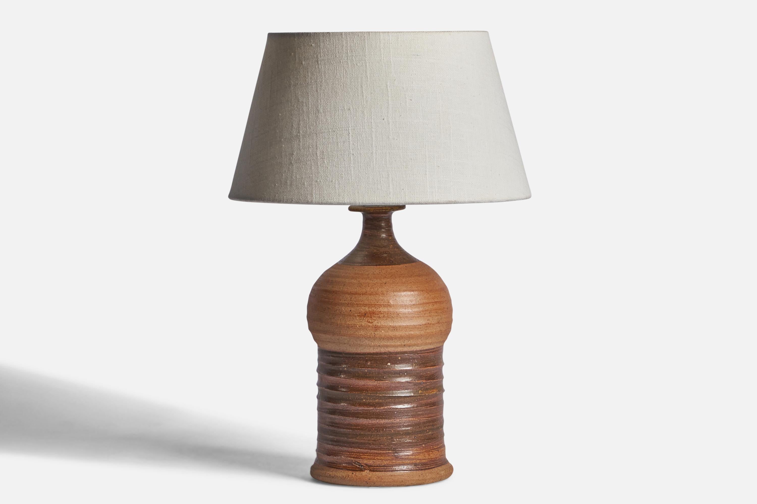 A brown-glazed stoneware table lamp designed and produced in Denmark, c. 1950s.

Dimensions of Lamp (inches): 11.65” H x 4.80” Diameter
Dimensions of Shade (inches): 7” Top Diameter x 10” Bottom Diameter x 5.5” H 
Dimensions of Lamp with Shade