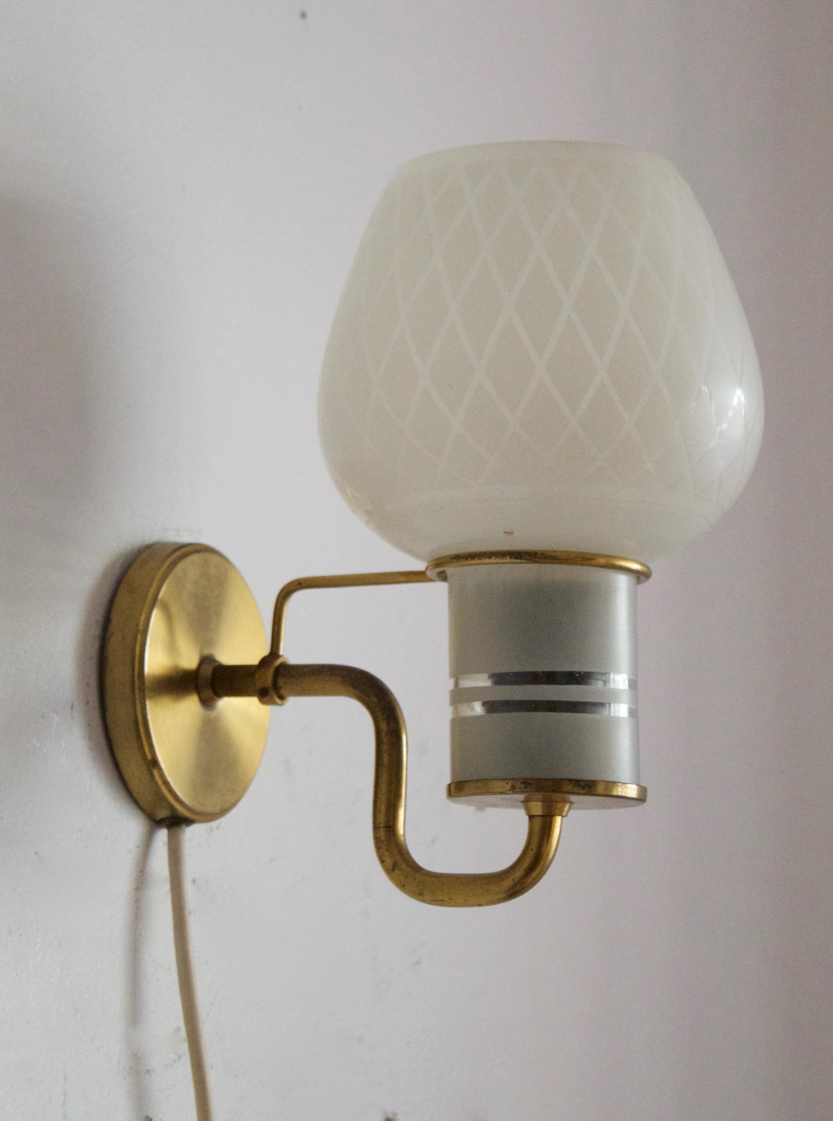 A functionalist wall light / task light, designed and produced in Denmark, 1940s-1950s. Features brass. Original finely ornamented glass difuser.
 
