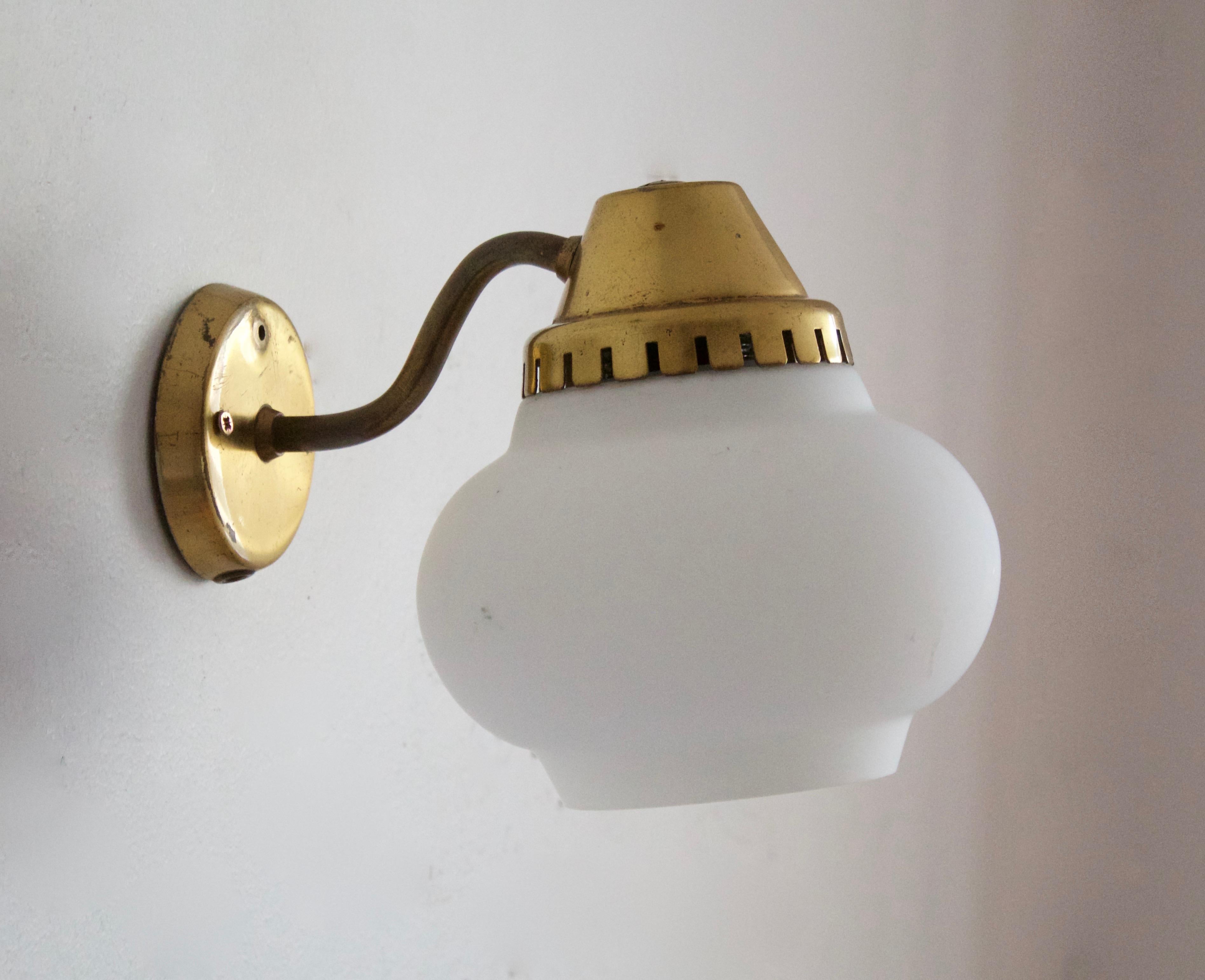 A functionalist wall light / task light, designed and produced in Denmark, 1940s-1950s. Features brass. Original glass difuser.
     