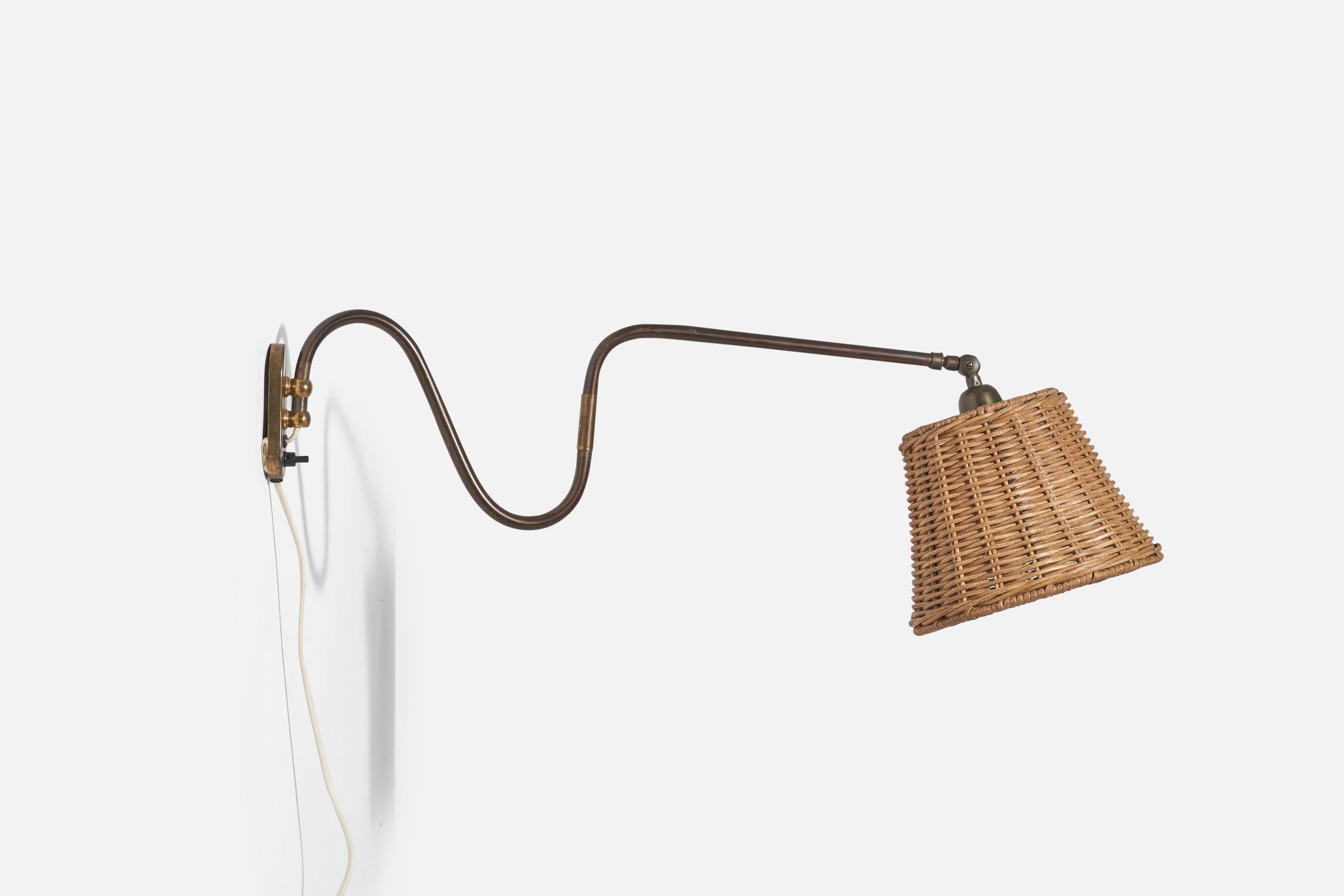 A brass and rattan wall light designed and produced in Denmark, 1940s.

Dimensions variable, measured as illustrated in first image.

Sold with Lampshade. Dimensions stated are of Sconce with Lampshade. 

Socket takes standard E-26 medium base