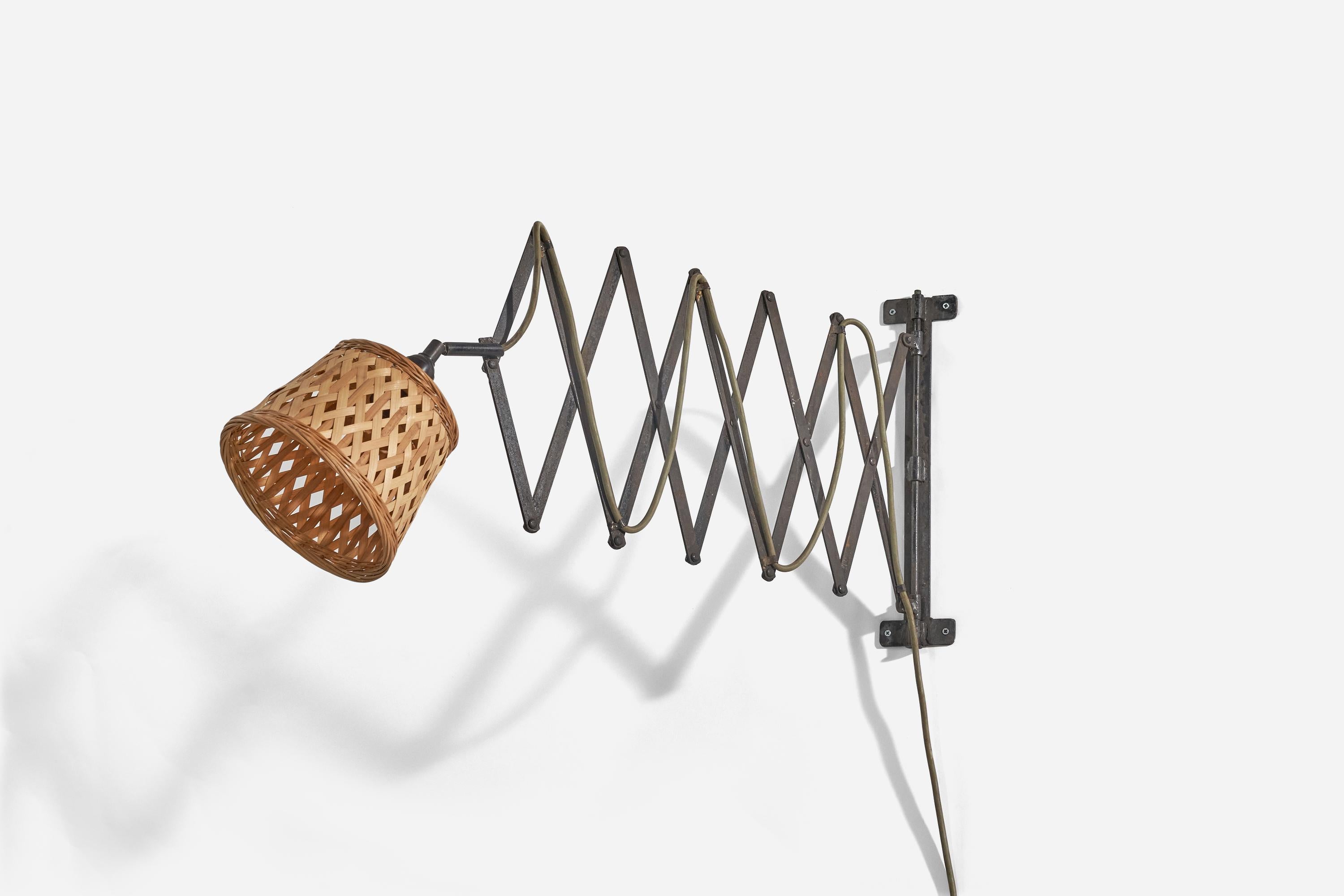 A metal and rattan wall light designed and produced in Denmark, 1940s.

Sold with Lampshade. 
Stated dimensions refer to the lamp with the lampshade.
Variable dimensions, measured as illustrated in the first image. 
 