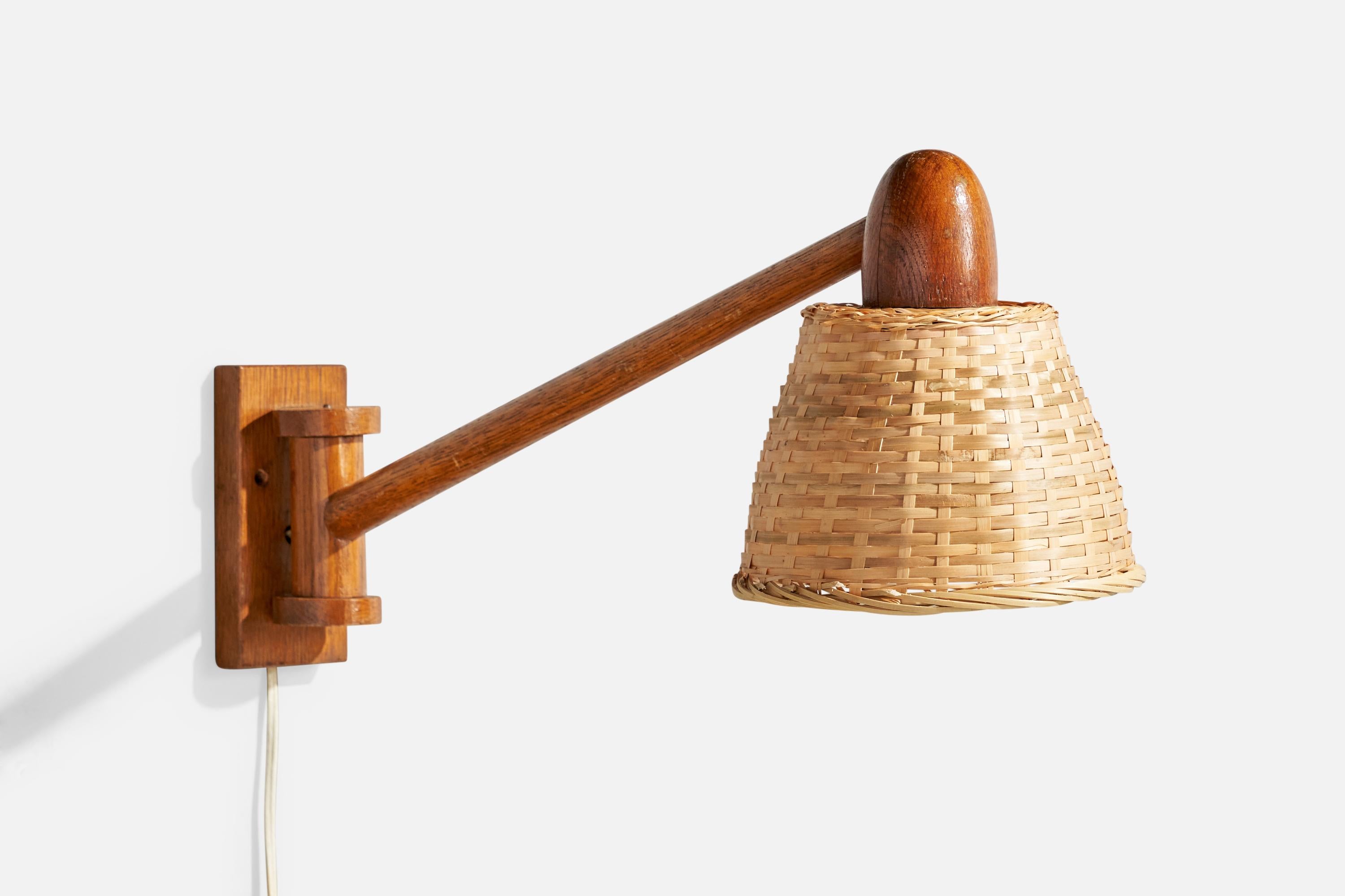 Un'applique regolabile in teak e rattan progettata e prodotta in Danimarca, negli anni '60 circa.

Dimensioni complessive (pollici): 10,5