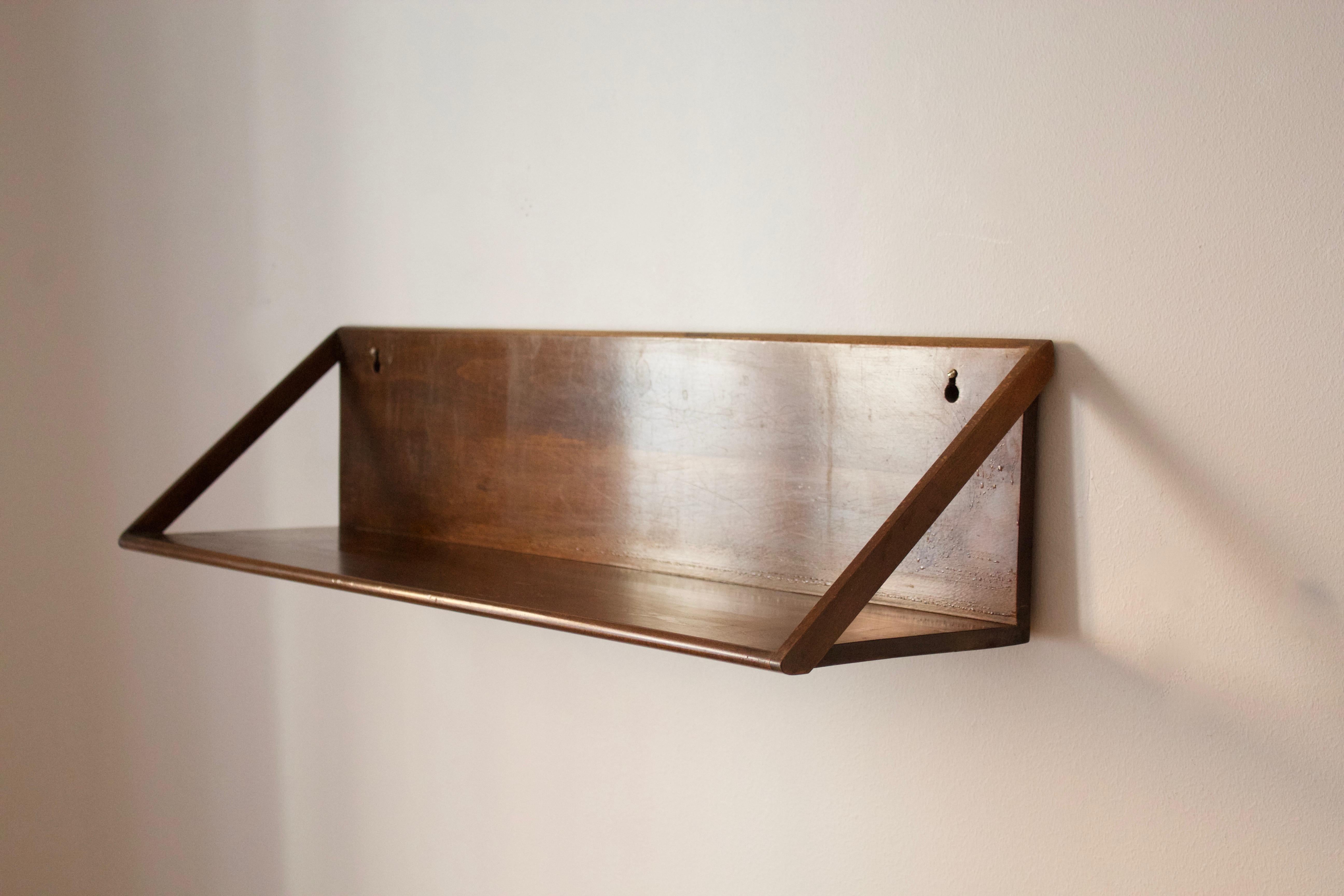 A minimalist wall shelf. Designed and produced in Denmark, 1950s.

Other designers of period include Axel Einar Hjorth, Pierre Jeanneret, Franco Albini, Alvar Aalto, and Kaare Klint.