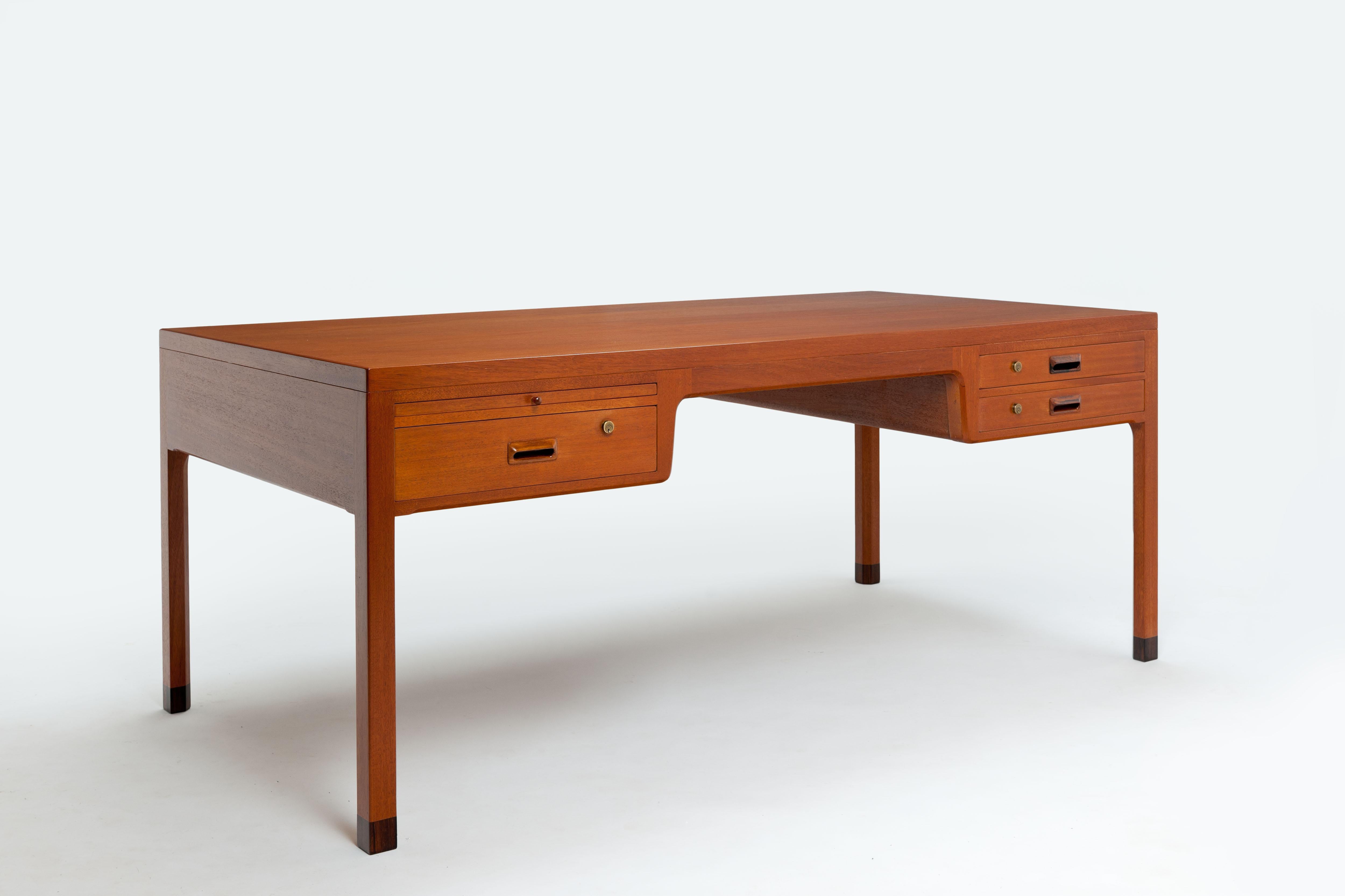 Beautiful distinguished Danish desk, made of mahogany (mainly solid) by Danish designers Ejner Larsen and Aksel Bender Madsen from 1960.
The desk is full of beautiful detailing such as the rejuvenated inside of the legs and the use of a dark