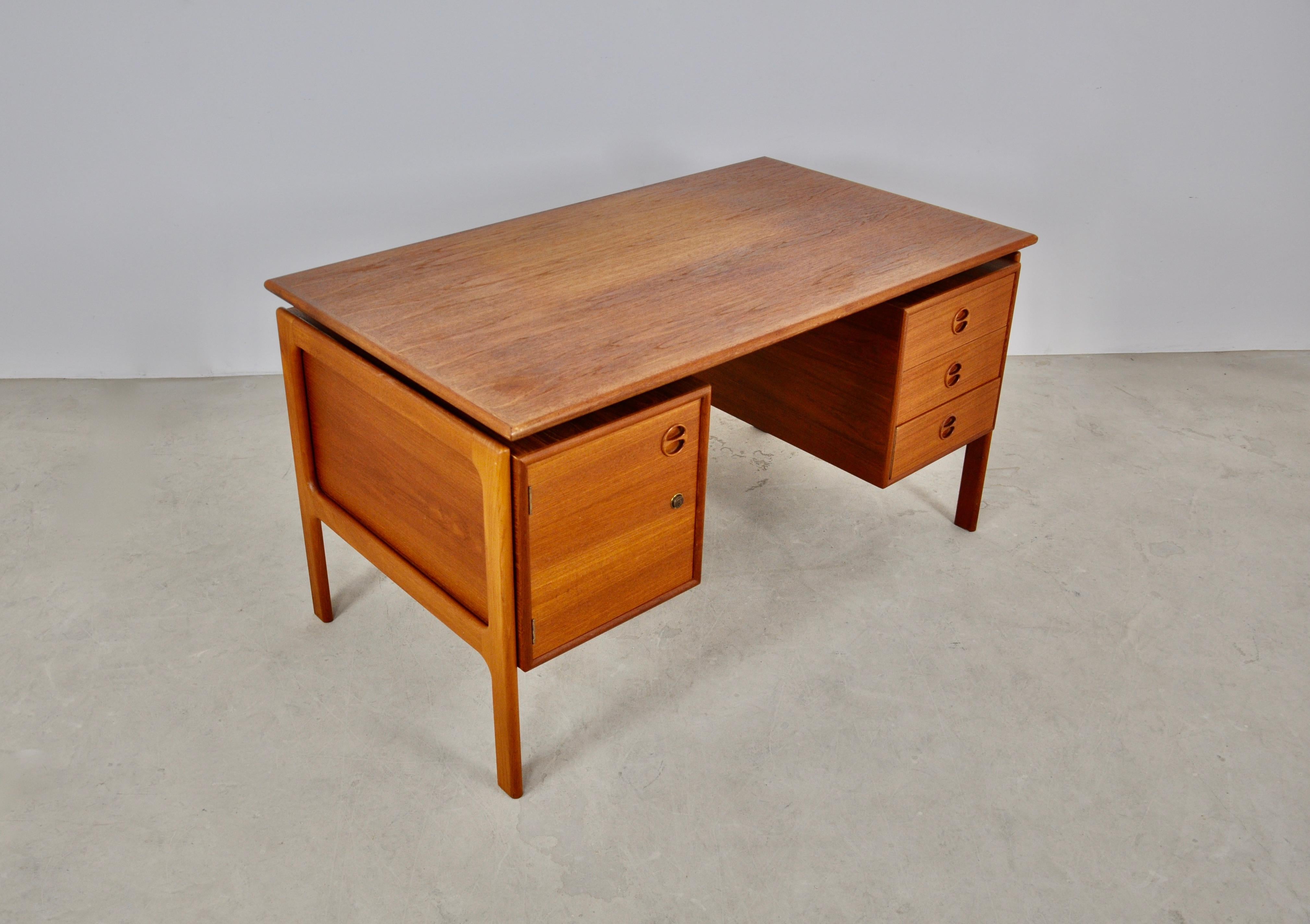 Teak desk with 3 drawers and a door. Wear due to time and age of the desk.