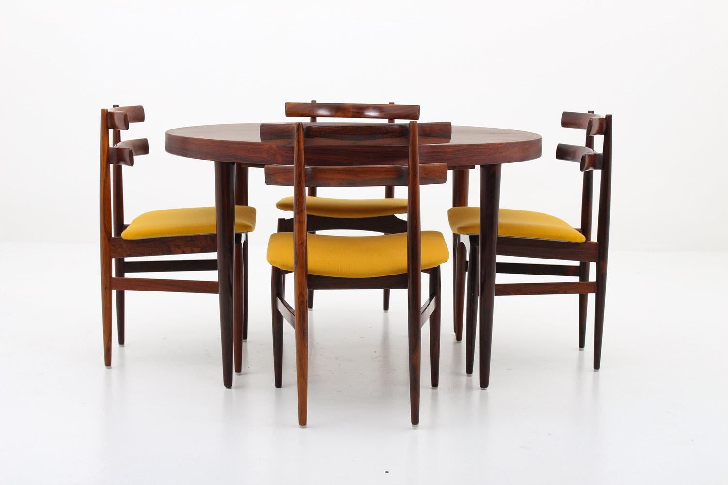 A stunning dining room set No. 30 by Poul Hundevad, Denmark. 
The chairs are made of solid rosewood. The backrests are beautifully curved and look like they have been melted together with the legs that are holding them. The front legs are cut off a