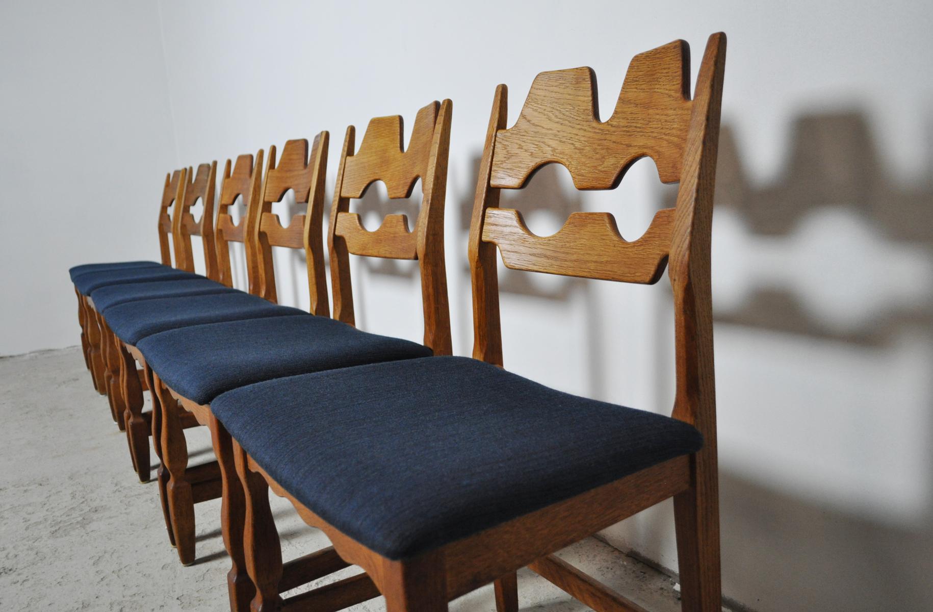 Set of 6 dining chairs designed by Henning Kjærnulf, made of solid oak and new upholstery with dark blue wool fabric. 

A design where rustic meets modernism design. Gently refurbished solid oak with a beautiful grain. More items available which can