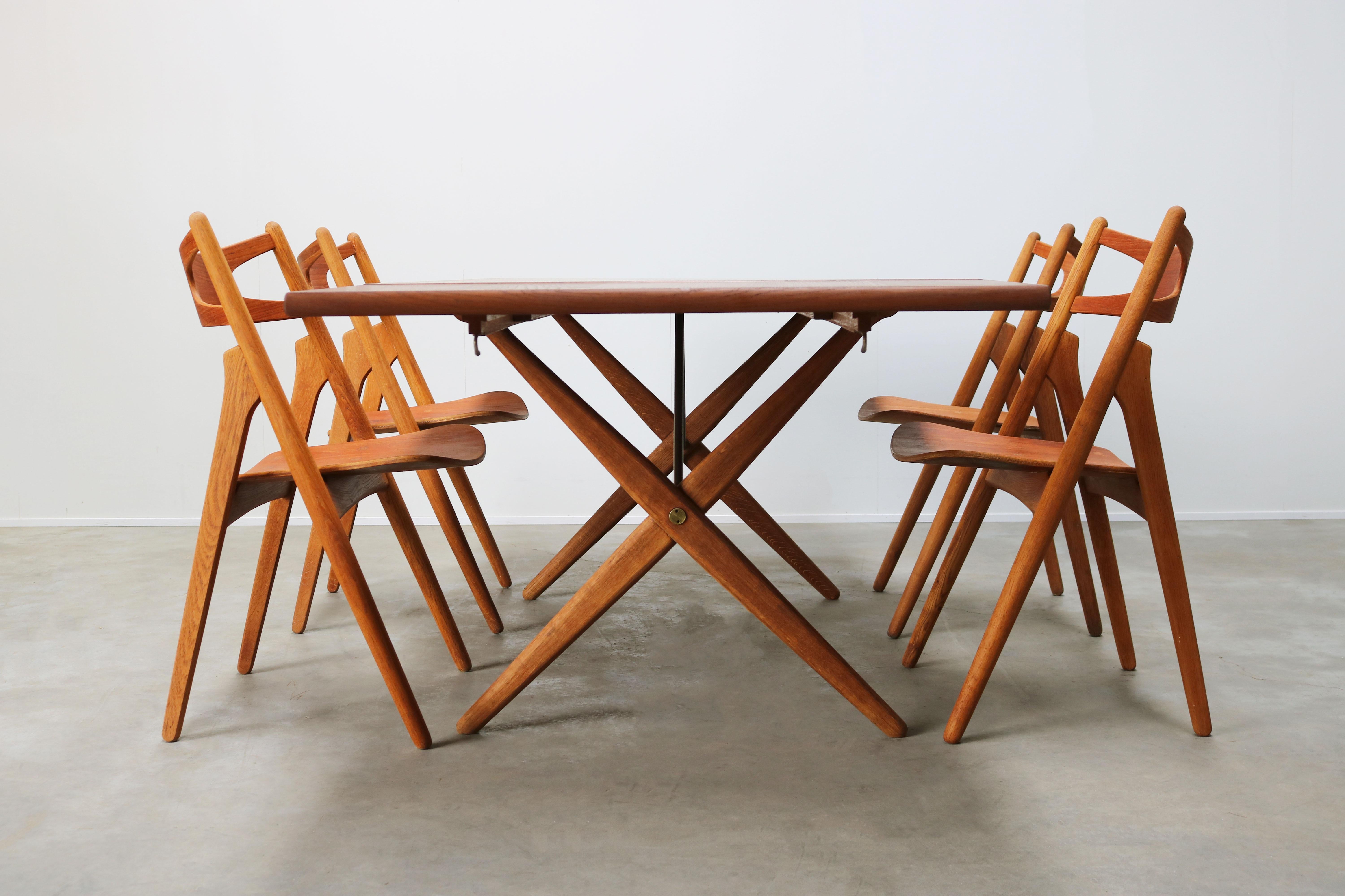 Wonderful Danish design dining room set by famous Danish design grandmaster: Hans J. Wegner for Andreas Tuck in the 1950s. The set consist of four Sawbuck chairs Model: CH29 and a cross-leg model: AT-309 table with extendable table leaves. Wonderful