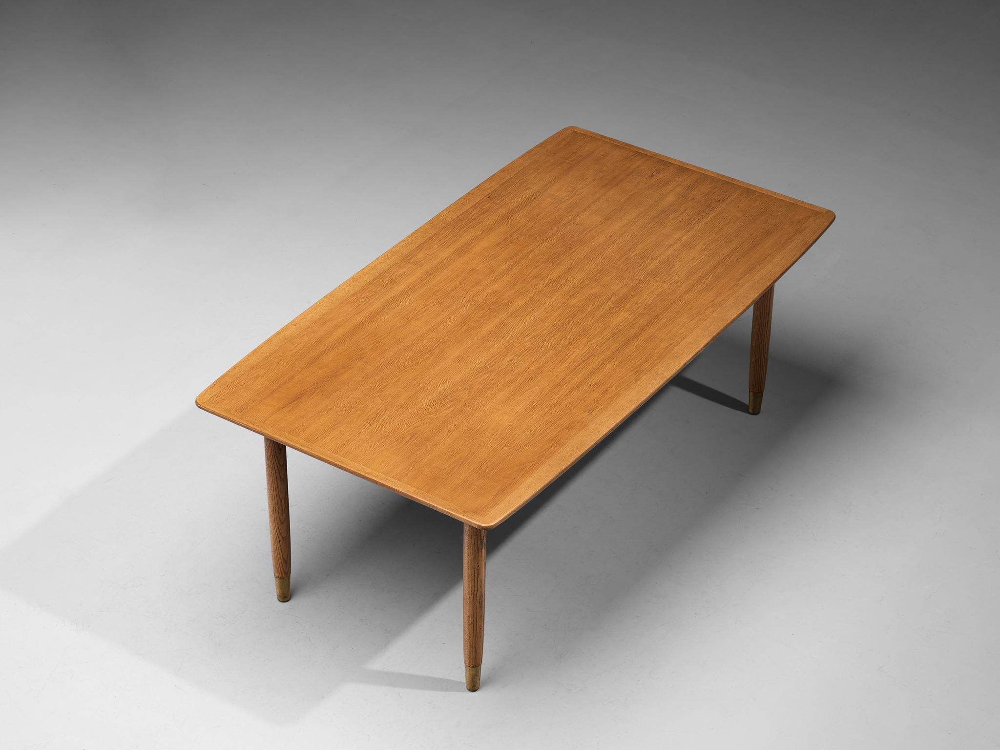 Dining table, oak, brass, Denmark, 1950s

Scandinavian Modern dining table with rectangular top. The warm colored top rests on four circular, tapered legs that have brass feet. This detail gives the design strength and characterizes this