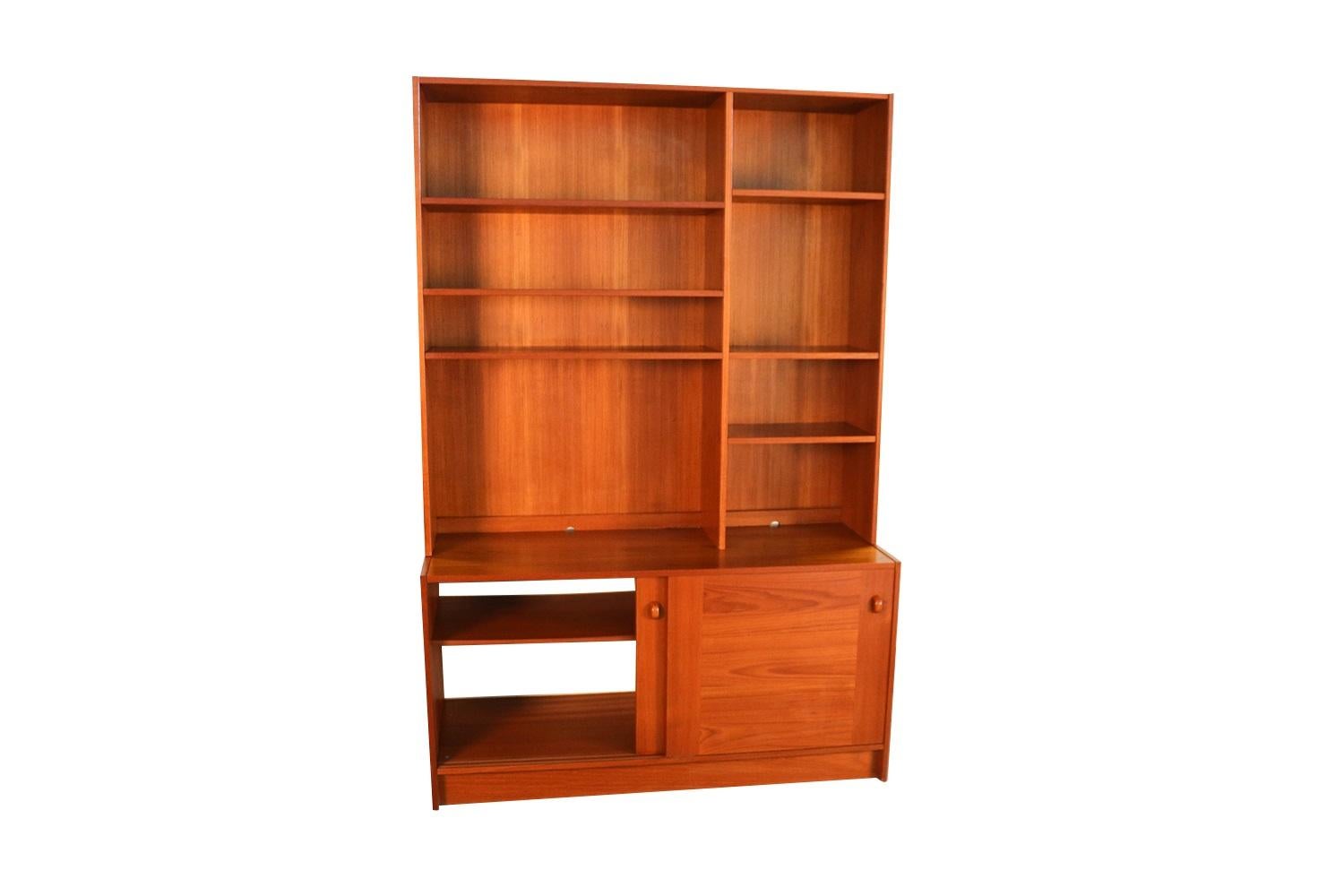 A two-piece hutch resting on a credenza base made in Denmark by Domino Mobler. A beautiful Danish modern teak credenza, wall unit, bookcase, beautifully embellished with bands of teak running perpendicular to main surface. This comes in two pieces
