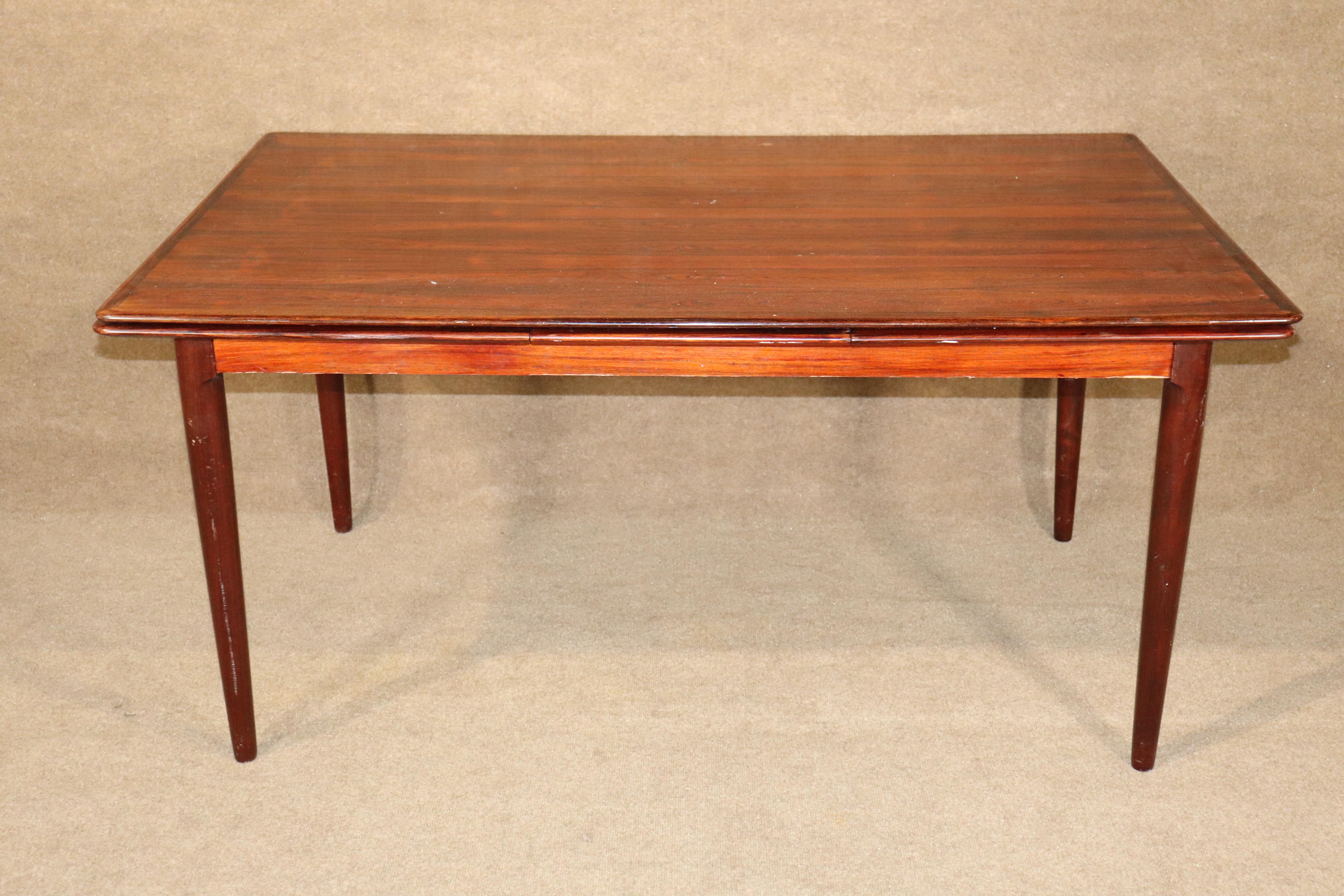 Mid-Century Modern dining table in rich rosewood grain. Danish made with two extra leaves that store underneath the table top, and pullout for more room.
Please confirm location NY or NJ.