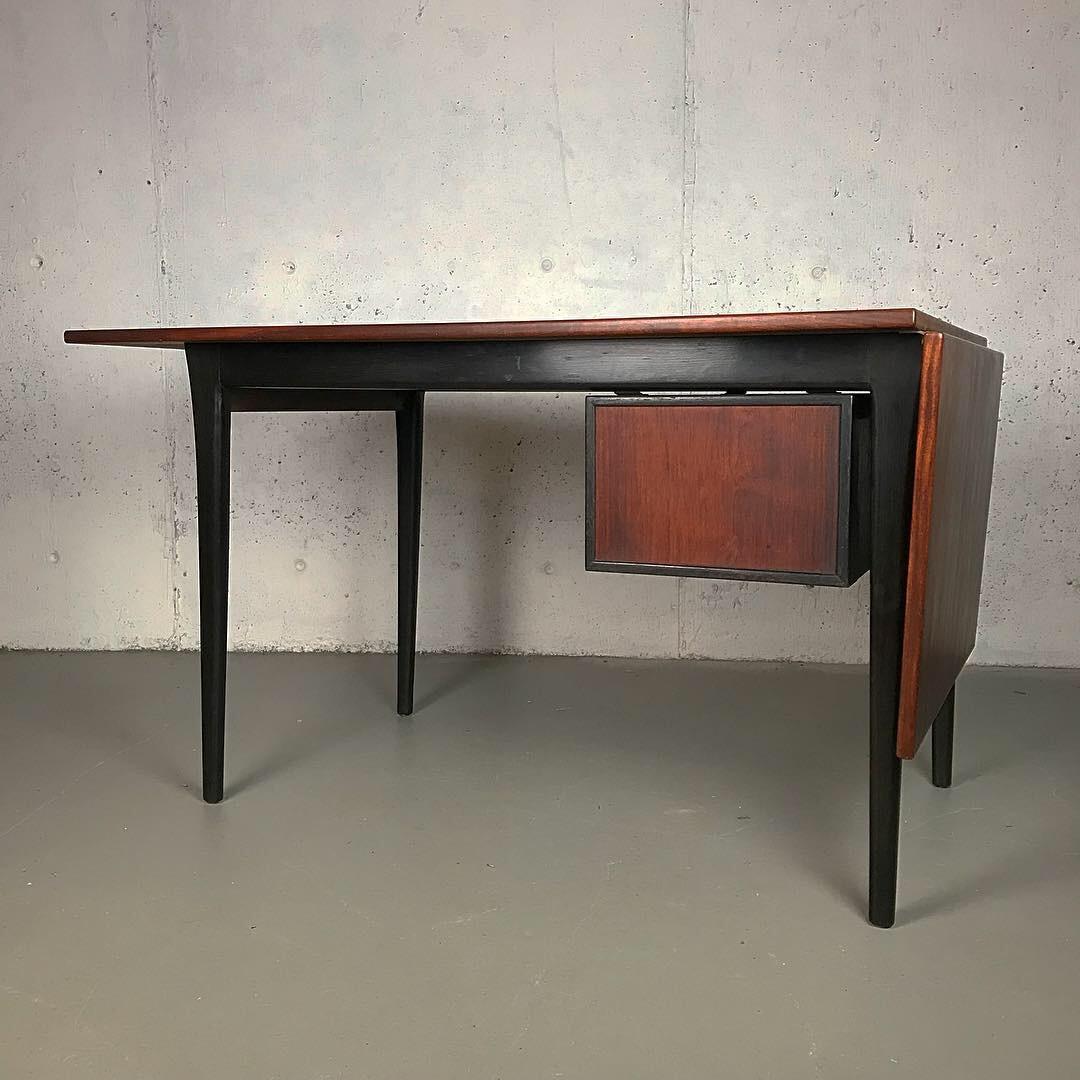 Early Danish desk in rosewood and ebonized oak in original condition. This unique trapezoid top desk had one owner. The rosewood is rich and dark, and the wear is very minor. The desk features a drop down leaf that can be brought to the top by