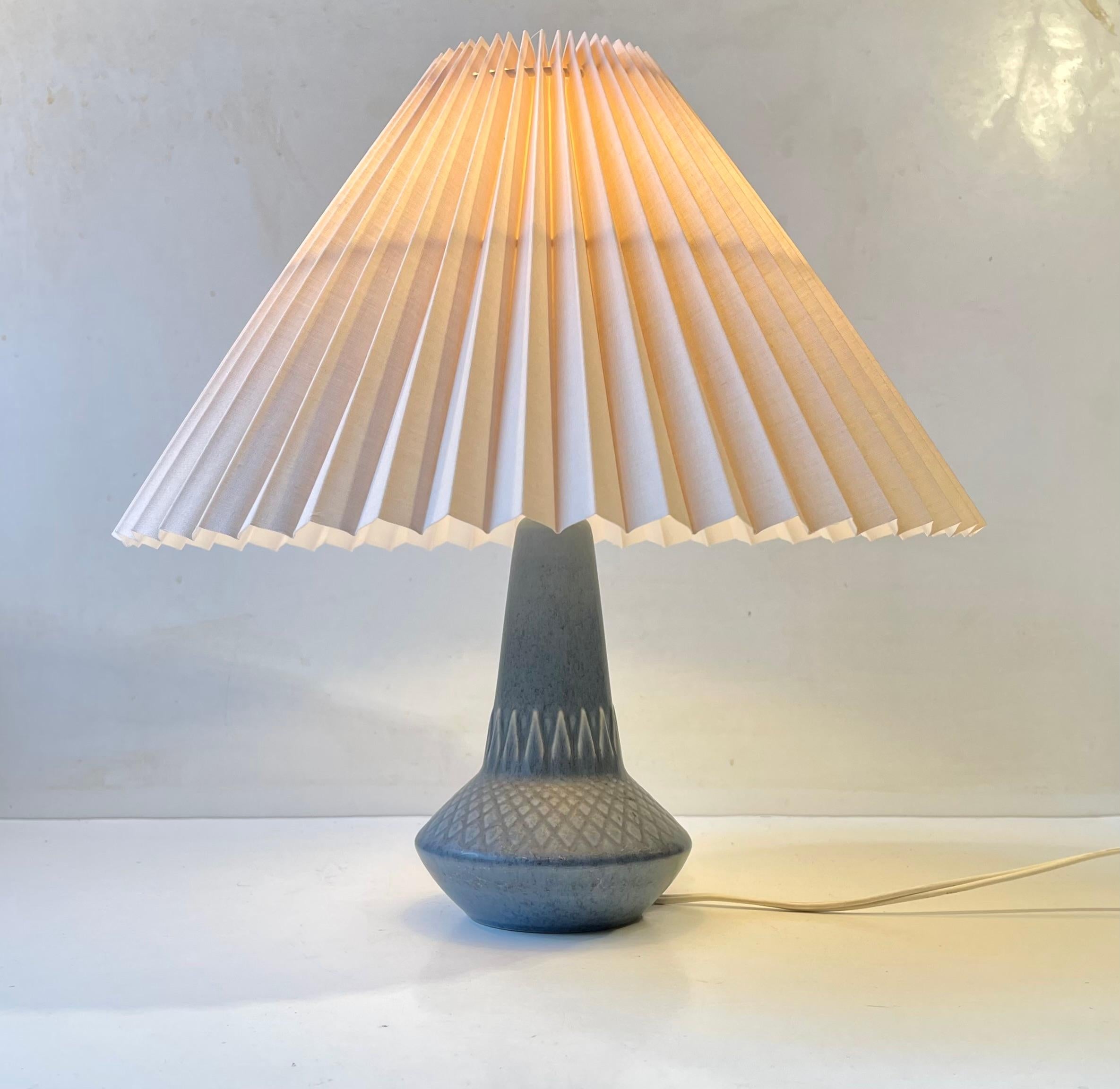 Lampe de table en poterie doucement émaillée avec des motifs géométriques, conçue par le céramiste danois Einar Johansen dans les années 1970. Signé vaguement EJ à la base. Magnifique condition vintage intacte. Nouvel abat-jour cannelé blanc danois