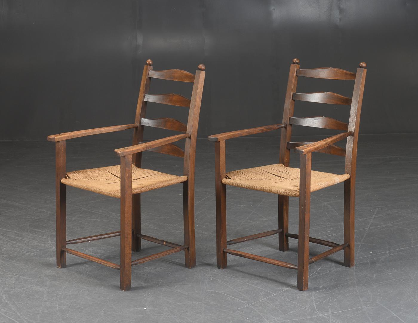 Great pair of country style armchairs made in Denmark in the early part of the 20th century. Hand carved from solid beech and stained. Over time the chairs have achieved an absolutely remarkable patina. The wood is in overall good solid condition as