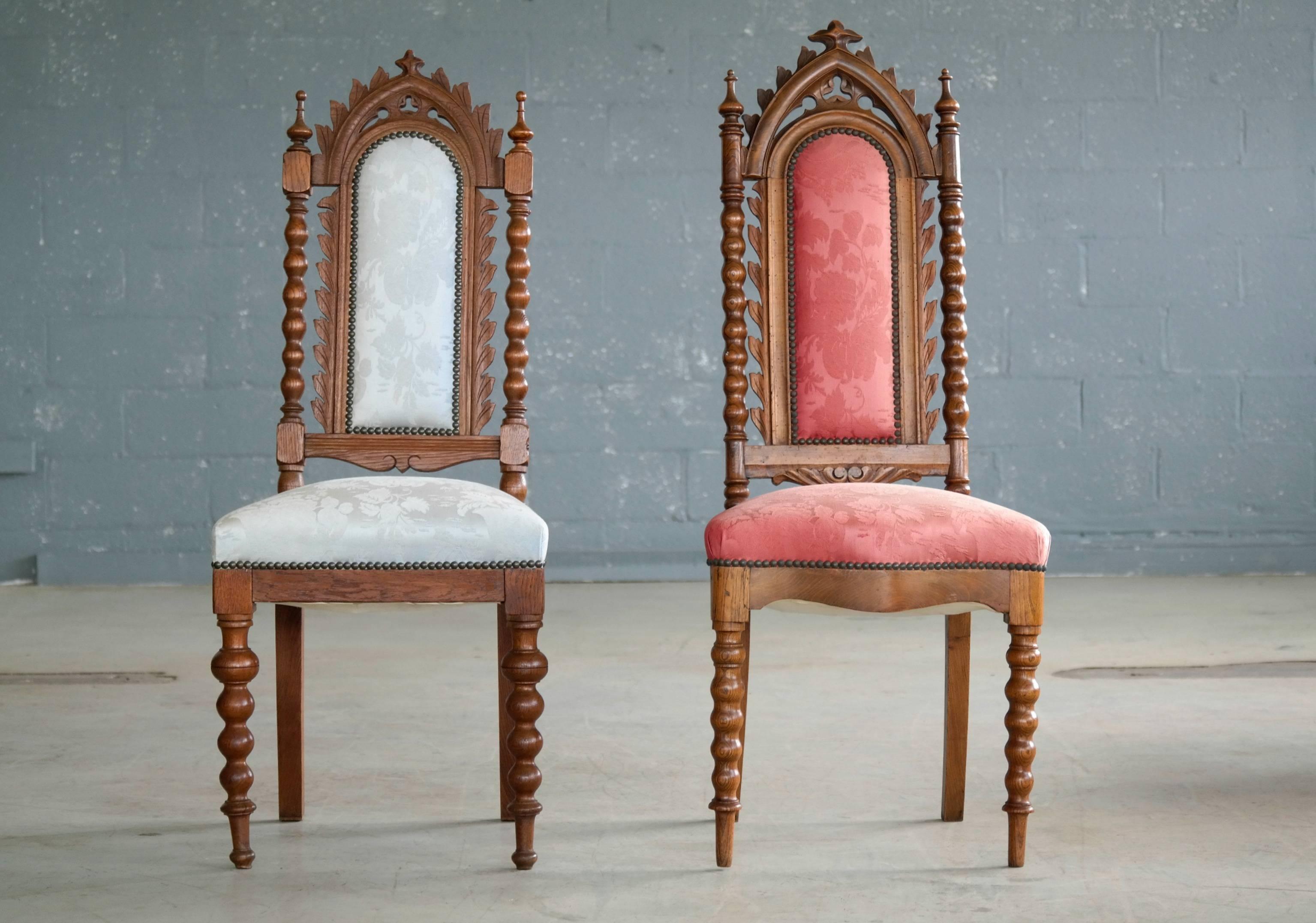 Beautiful pair of Danish early 20th century neo-Gothic side chairs in carved polished oak in the style of Thorvald Bindesboll. While the chairs are not a perfect pair they are just perfect together - like the king and the queen of the manor. Very