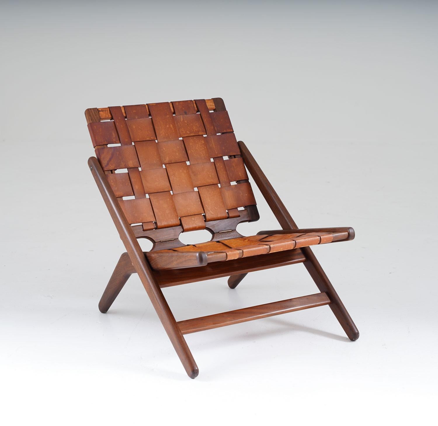 Stunning folding chair by Arne Hovmand-Olsen for Jutex.
The frame of the chair is highlighted by two sculptural shaped pieces of wood, crossing each other on the sides of the chair. It's upholstered in cognac-colored leather with perfect patina.
