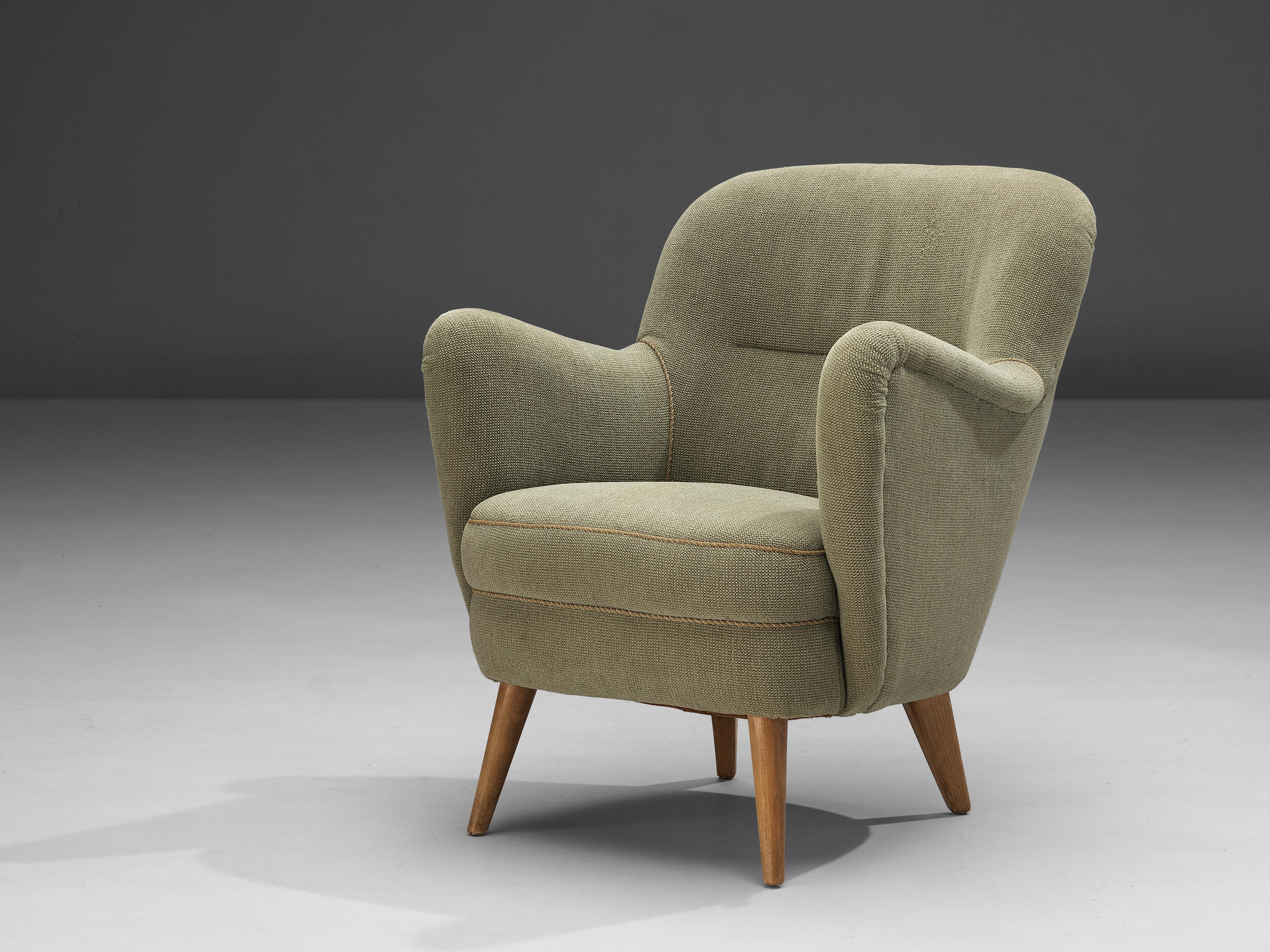 Lounge chair, beech, fabric, Denmark, 1950s. 

A sophisticated Danish easy chair with beech legs. The sleek, tapered beech legs form a nice interplay with the elegant body of this chair. The round back and armrest create an inviting feeling. The