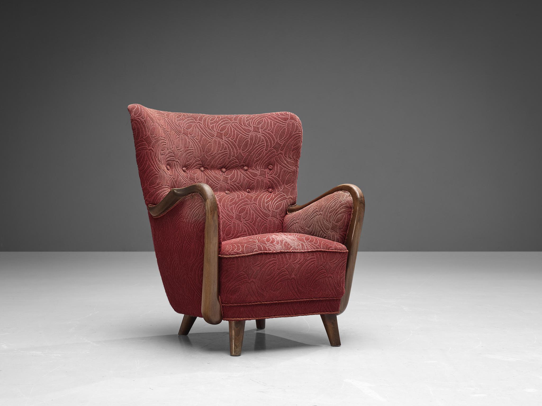 Easy chair, fabric, stained beech, Denmark, 1940s. 

This Danish wingback chair is upholstered with the original fabric that shows signs of age and use. The solid oak frame is sculptural and curved and flows organically into the armrests. The
