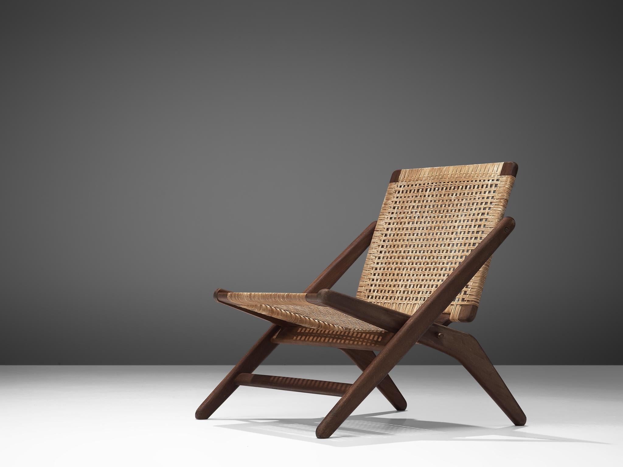 Arne Hovmand-Olsen, easy chair, beech and cane, Denmark, 1960s.

 
This Minimalist, Scandinavian Modern lounge chair features a scissor-like solid beechwood frame with woven cane seat. This folding chair is equipped with an inventive folding