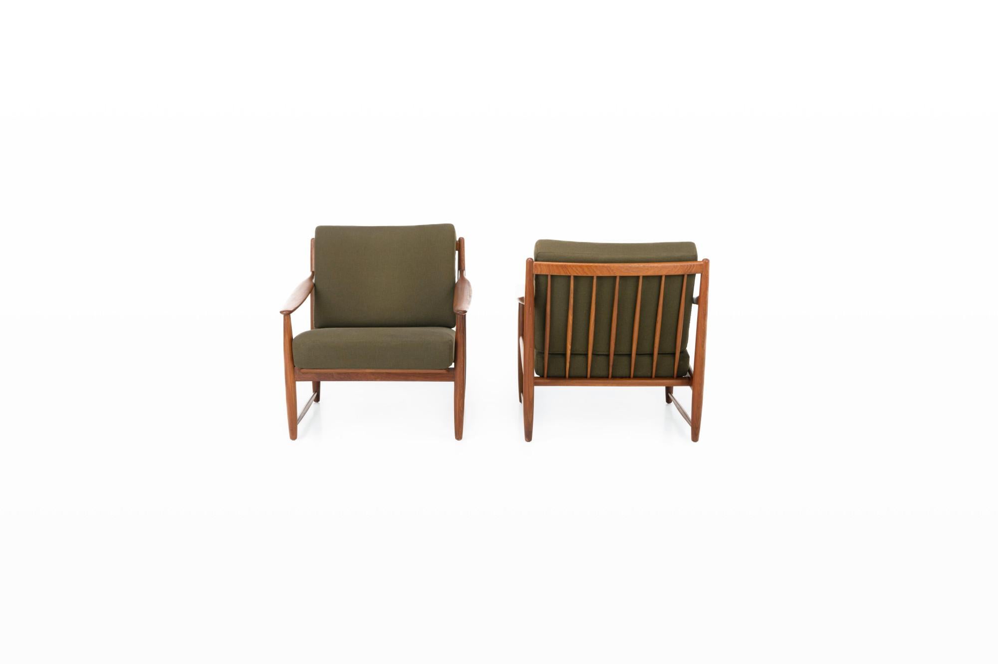 Set of two easy chairs produced in Denmark in the 1960s. The armchairs have a teak frame and the cushions still have the original khaki green fabric.