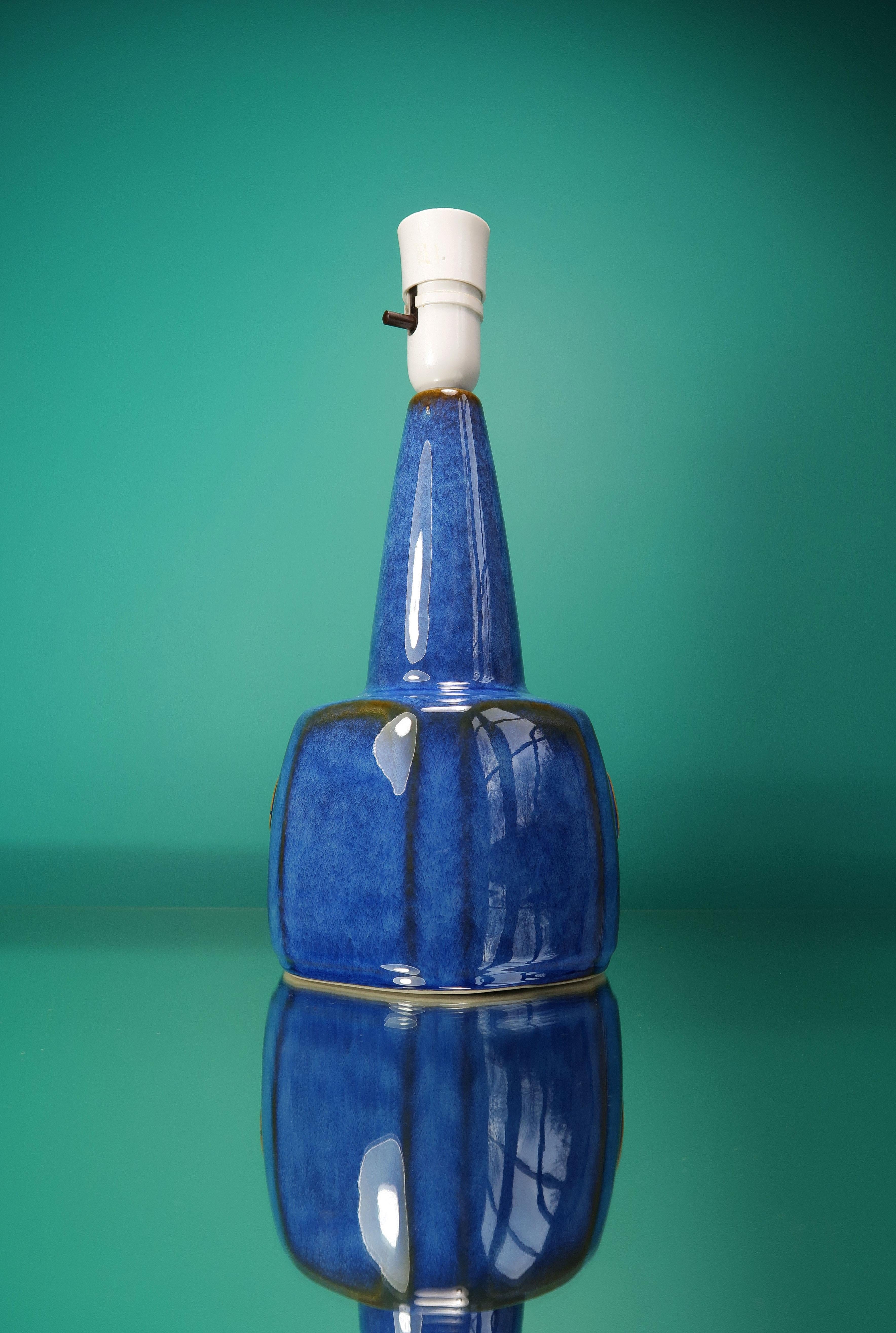 Classic Danish Mid-Century Modern table lamp by designer Einar Johansen. Manufactured by Søholm Stentøj on the island of Bornholm in the 1960s. Smooth and shiny cobalt and azure blue runny glaze over caramel glaze. Graphic circular symbol on belly.