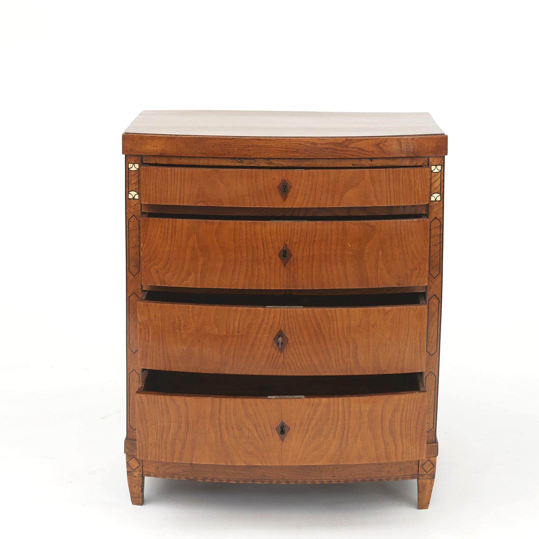 Elegant Danish Empire chest of drawers with curved front. Elm veneer with ebony marquetry decor, bone inlay flanking the top drawer.
Copenhagen, Denmark, circa 1810.
