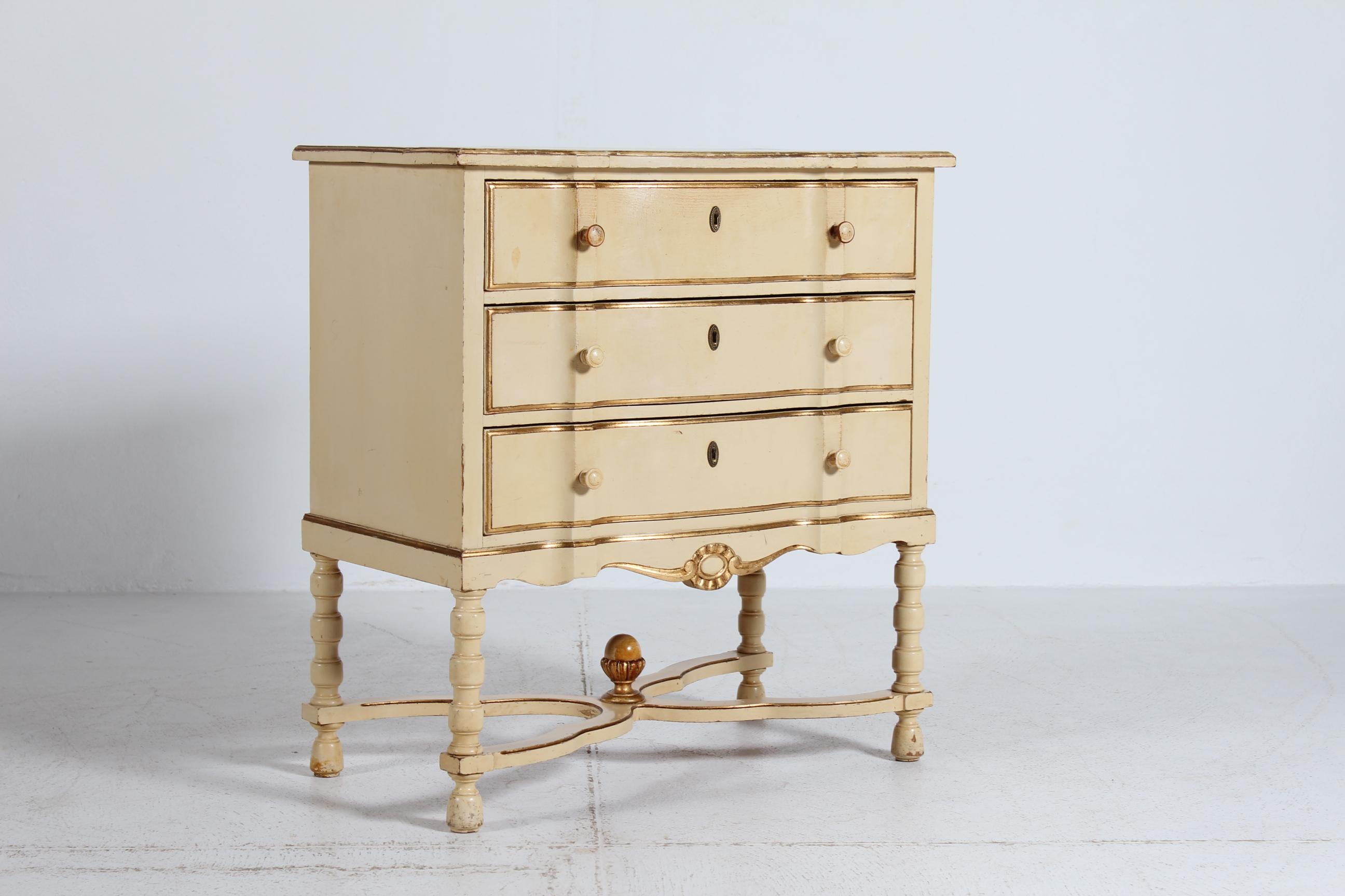 Cassettone ondulato in stile impero danese a tre cassetti su gambe alte in legno di pino massiccio. Realizzata a mano da un mastro falegname danese negli anni '30.

La cassapanca è decorata con vernice color panna e personale dorato.

Ottimo stato