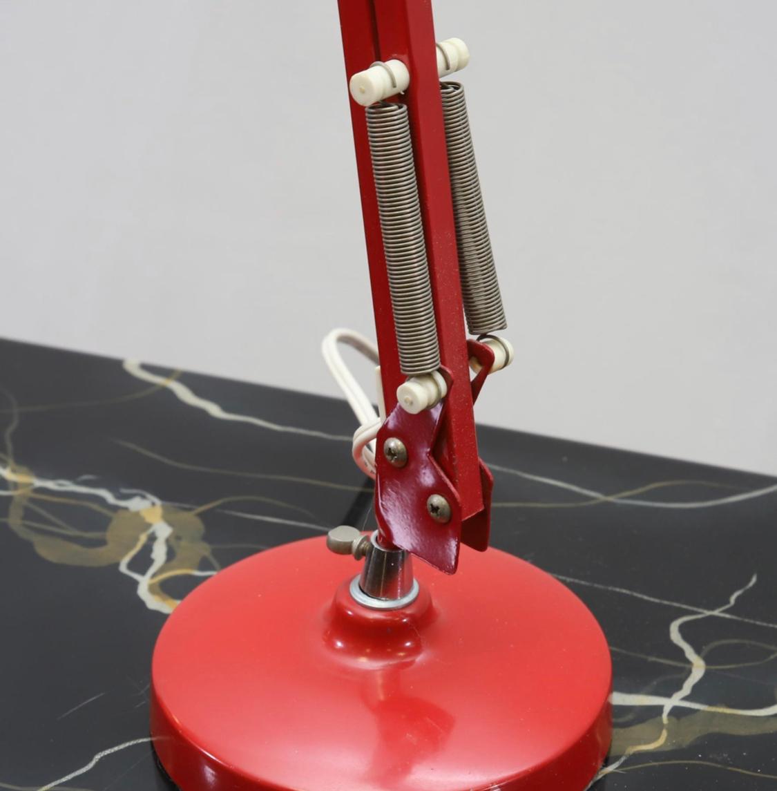 Fantastic articulating Danish lamp. Easily adjusted thanks to the spring tension mechanism. Red enameled steel provides stability and is quite durable. Handsome patina. Tested and works. Perfect for use at a desk or beside the bed as a reading lamp.