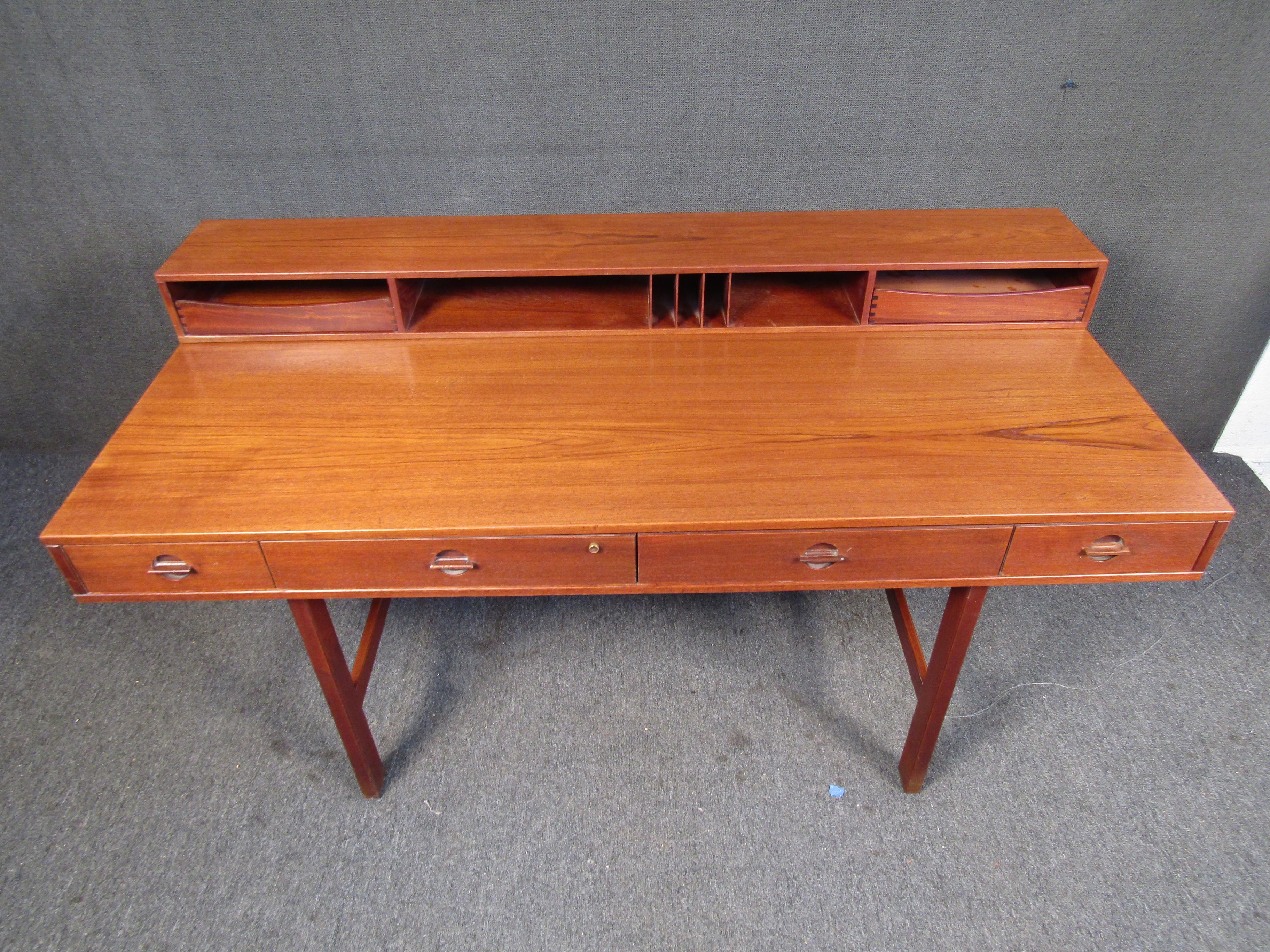 With a convertable hutch that folds down, multiple drawers for storage, and rich teak wood, this desk by Peter Lovig Nielson is a Mid-Century Modern gem. Please confirm item location with seller (NY/NJ).